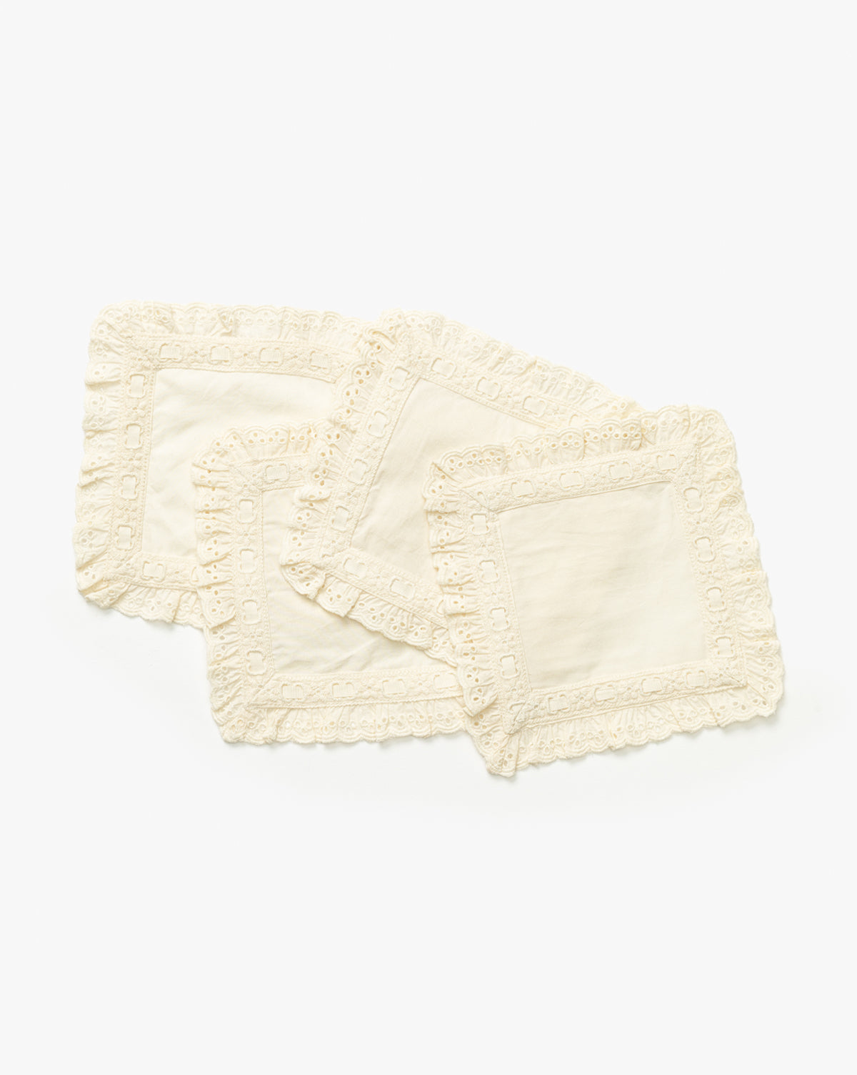 The Lace Trim Cocktail Napkins (Set of 4) are stacked against a white background, each with vintage-inspired scalloped lace borders—an elegant choice for your table decor, by McGee & Co.