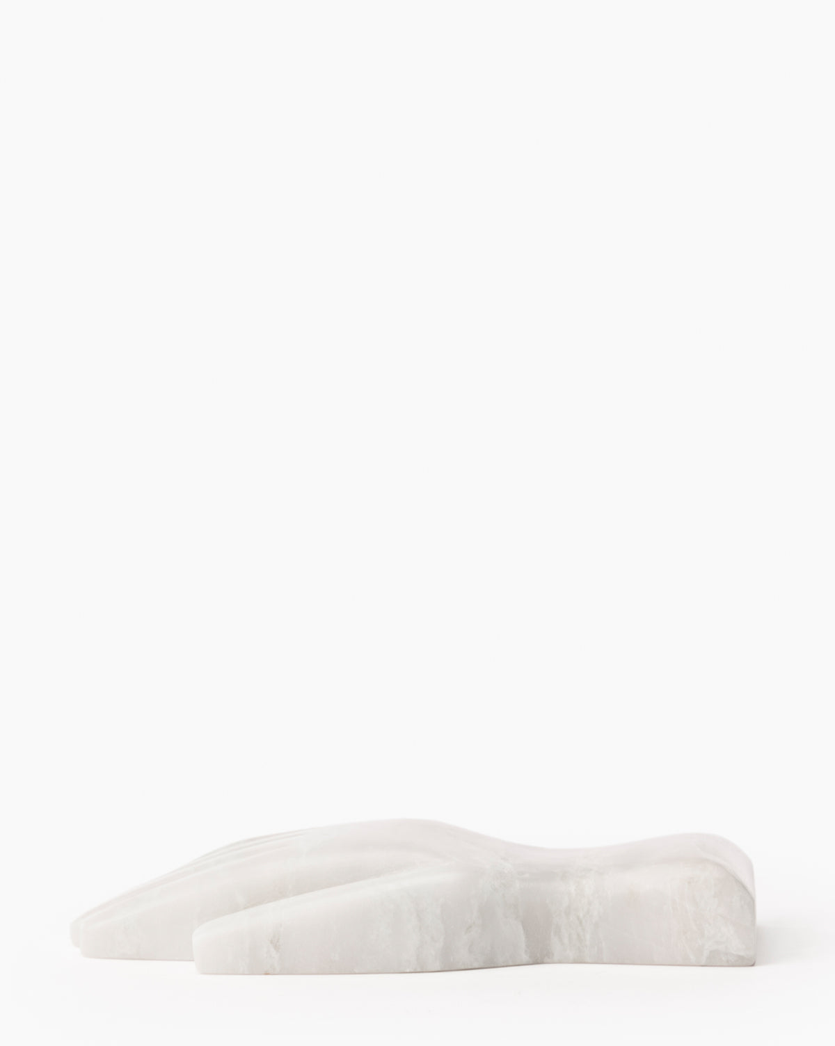 The Lady Onyx Hand Object rests flat on a white surface against a plain background. Its smooth, minimalist design subtly complements modern interiors, making it an ideal choice for contemporary decor.