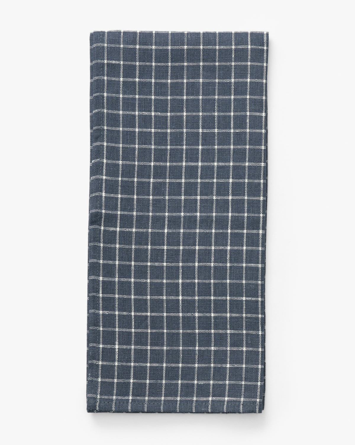 The Lancaster Linen Tea Towel, featuring a neatly folded navy and white check design, is displayed on a plain white background—a timeless kitchen staple, by McGee & Co.