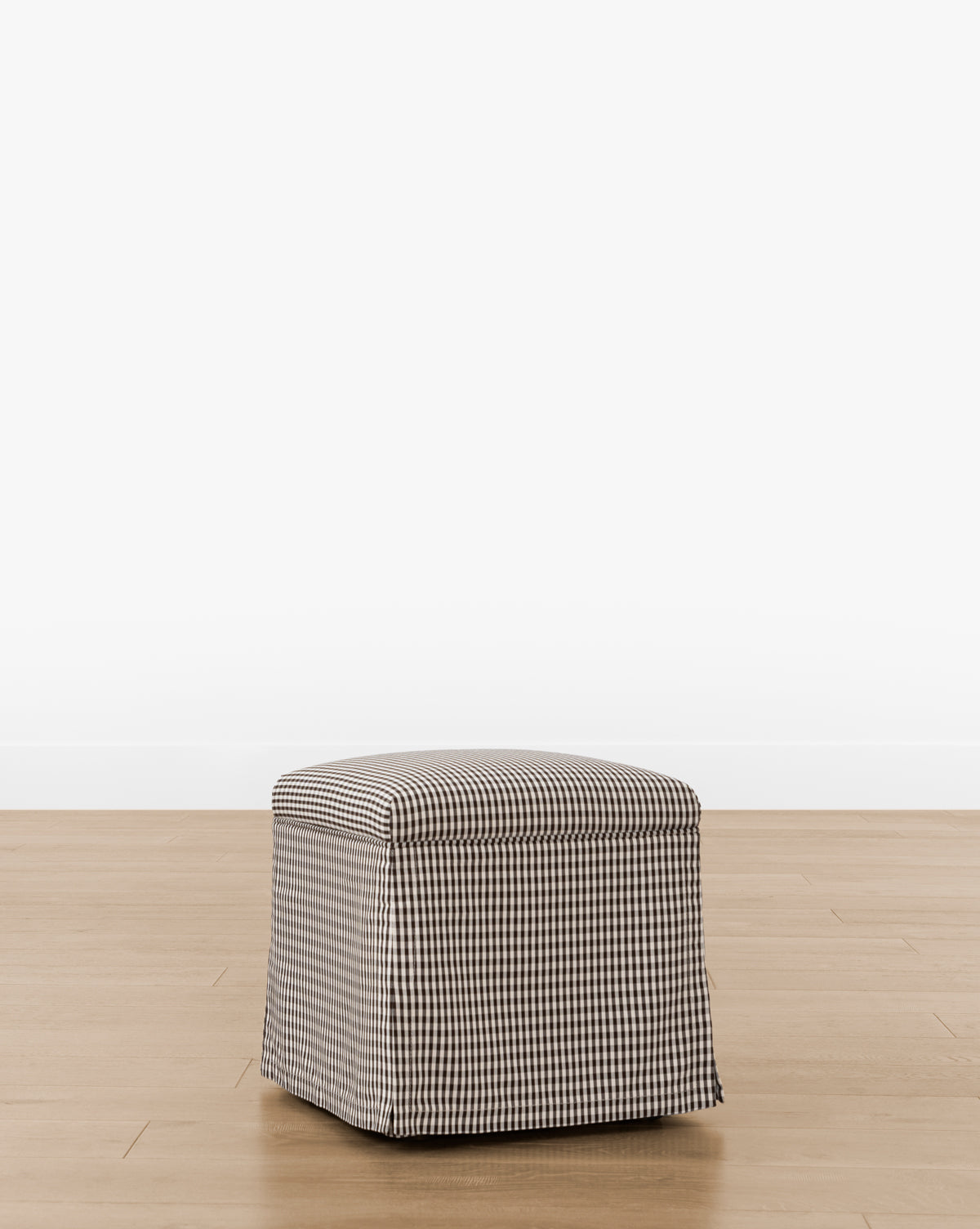 The Makerspalm Latimer Ottoman (Ready to Ship) features a black and white gingham checkered cover, crafted from high-quality fabrics—perfect as a functional accent piece for any room. McGee & Co.