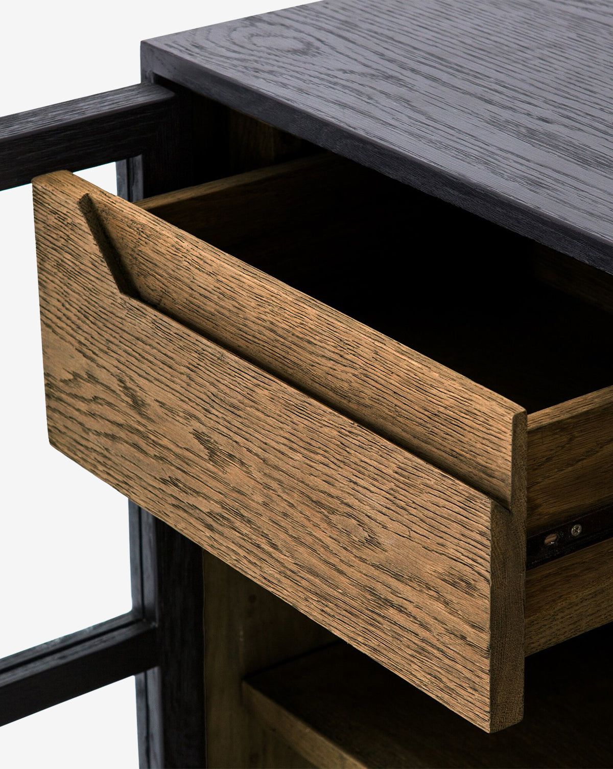 A close-up of the Laura Sideboard reveals a partially open drawer, showcasing its natural oak wood grain and dark frame, set against a light background.