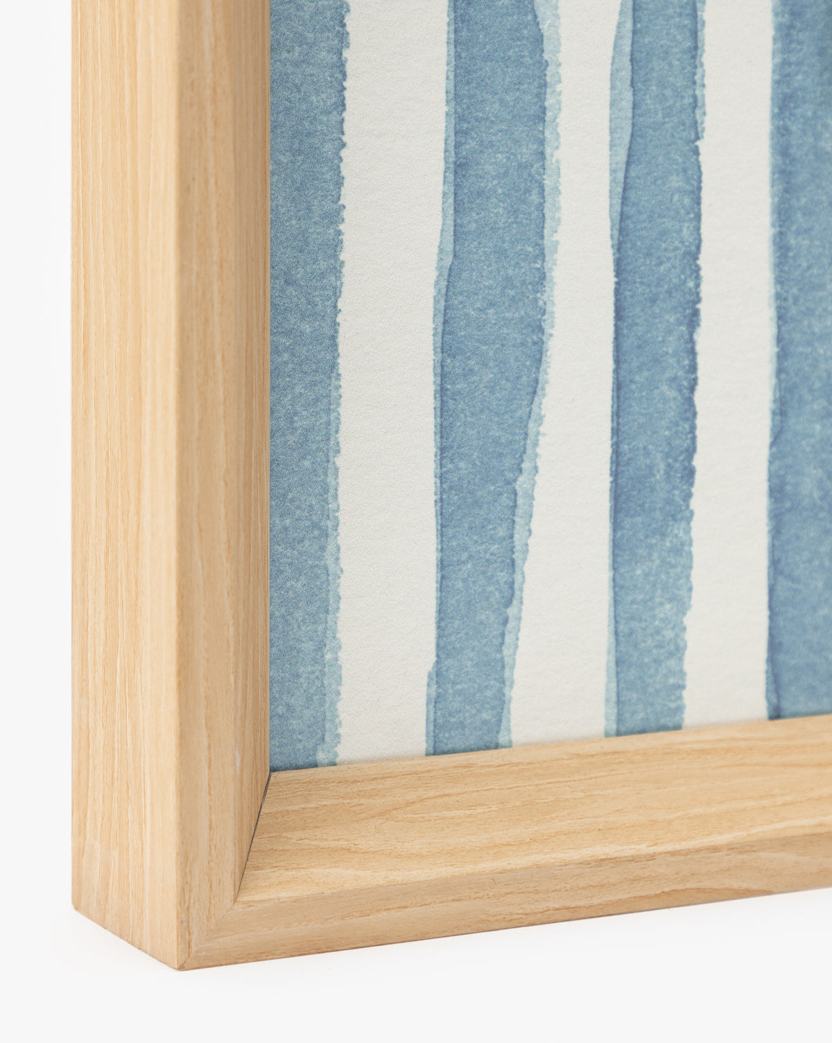 Close-up of the corner of a light wooden picture frame holding Leaping Doe among the Flowers artwork, showcasing hand-deckled edges and vertical blue watercolor stripes—a stylish decor accent, by McGee & Co.