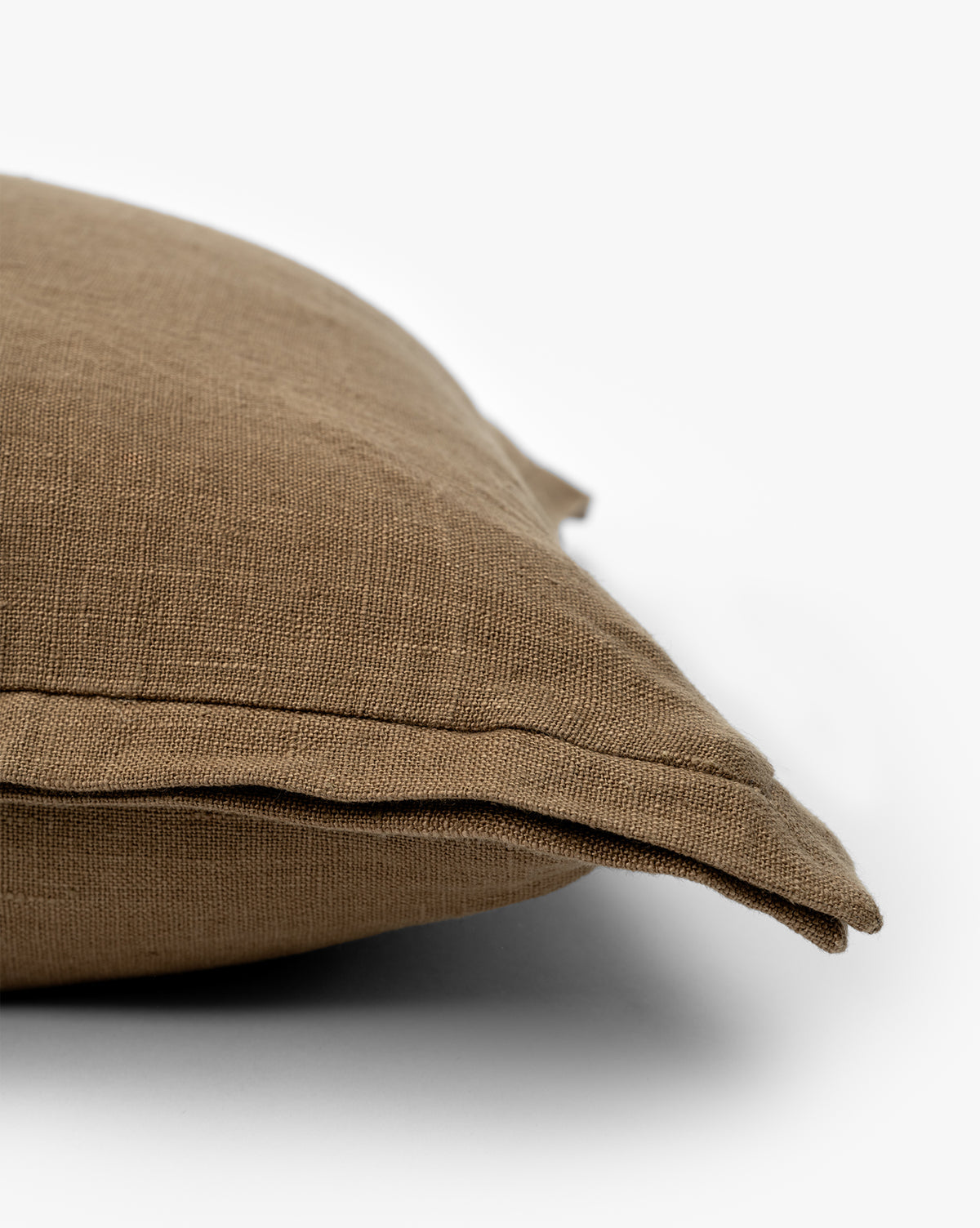 A close-up of the Liam Double Flange Pillow Cover in brown highlights its textured linen fabric, visible double flange detail, and intricate corner design against a white background, by McGee & Co.