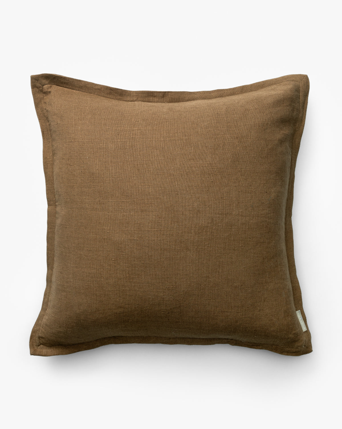 The Liam Double Flange Pillow Cover is a square, brown linen pillow cover with double flange edging, visible stitching, and a small white label on the bottom right corner, displayed on a plain white background by McGee & Co.