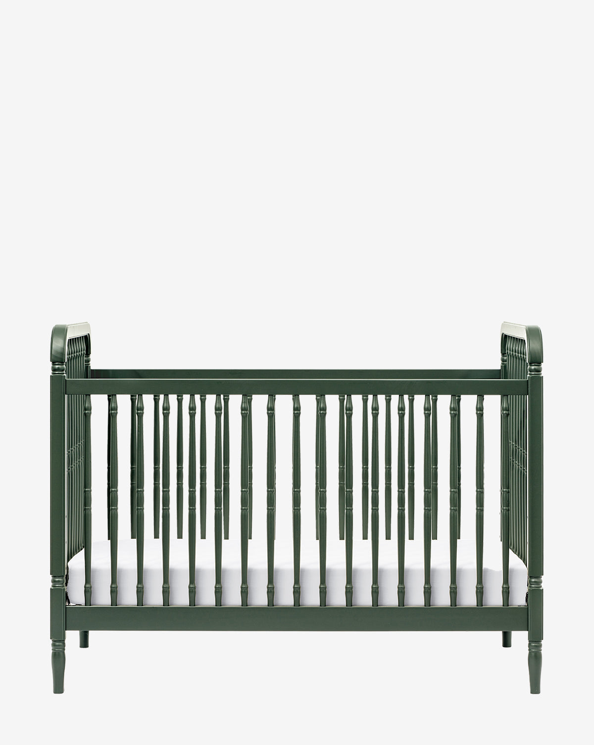 The Liberty 3-in-1 Convertible Spindle Crib with Toddler Bed Conversion Kit, shown here in dark green with vertical slats and classic legs, includes a white mattress and is displayed against a plain white background by McGee & Co.