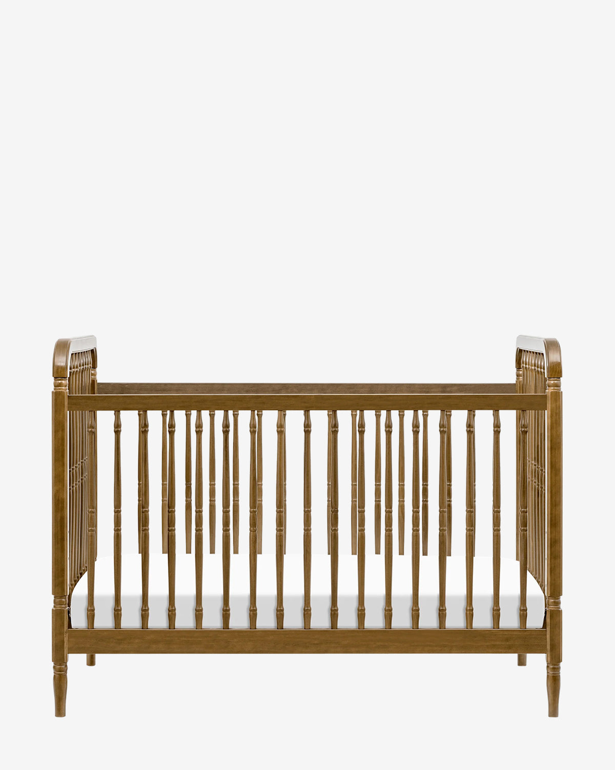 The Liberty 3-in-1 Convertible Spindle Crib with Toddler Bed Conversion Kit features solid pine wood, vertical slats, and a flat white mattress. Shown from the front against a plain white background for versatility and style by McGee & Co.