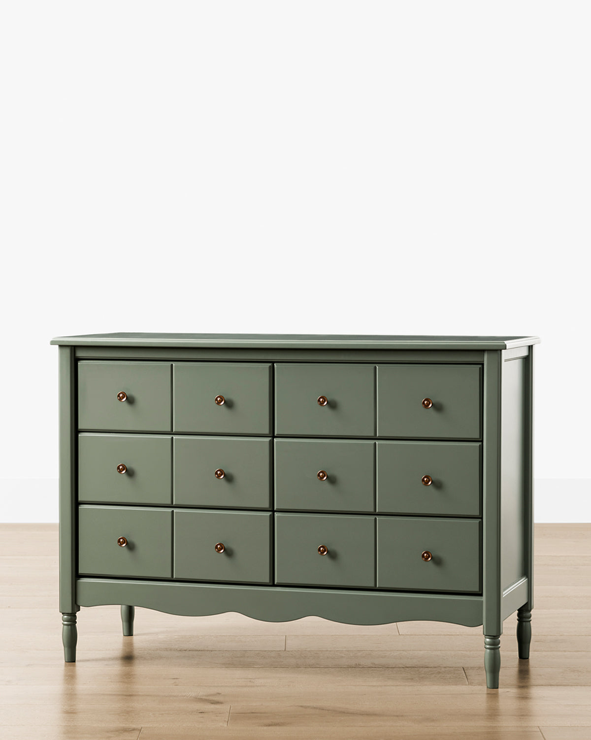 The Liberty 6-Drawer Assembled Dresser, made from sustainable pine wood with round knobs and turned legs, stands on a light wooden floor against a plain white background, by McGee & Co.