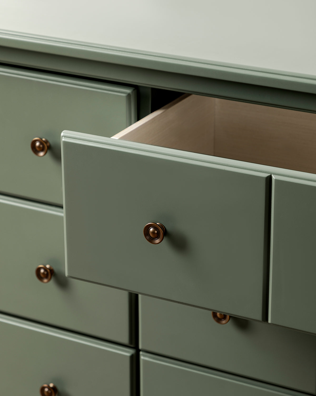 The Liberty 6-Drawer Assembled Dresser features gold knobs and a vintage design, with one drawer partially open to display its empty, sustainable pine wood interior, by McGee & Co.