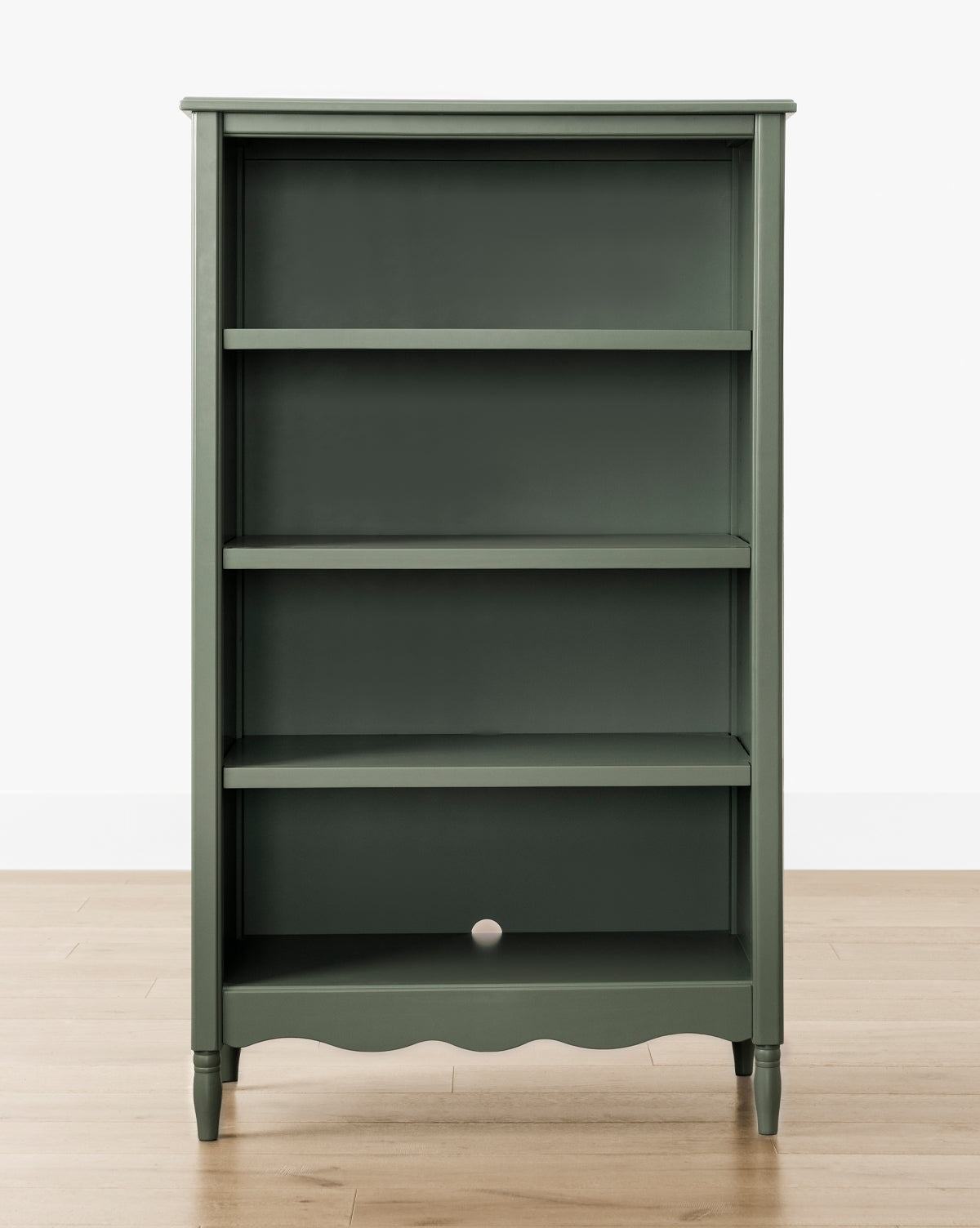 The Liberty Bookcase, in dark green with four shelves and a small back panel hole, displays heirloom craftsmanship, by McGee & Co. It stands on a light wood floor against a white background.