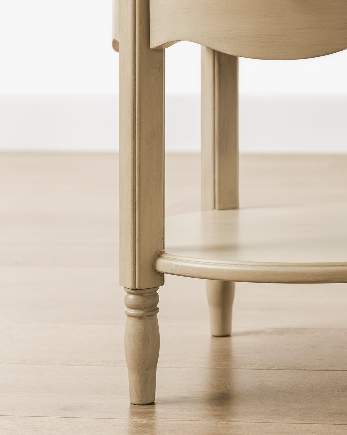 The Liberty Nightstand features turned legs and a circular bottom shelf, shown on a light wood floor against a white wall. GREENGUARD Gold Certified, its perfect for use as a nursery nightstand by McGee & Co.