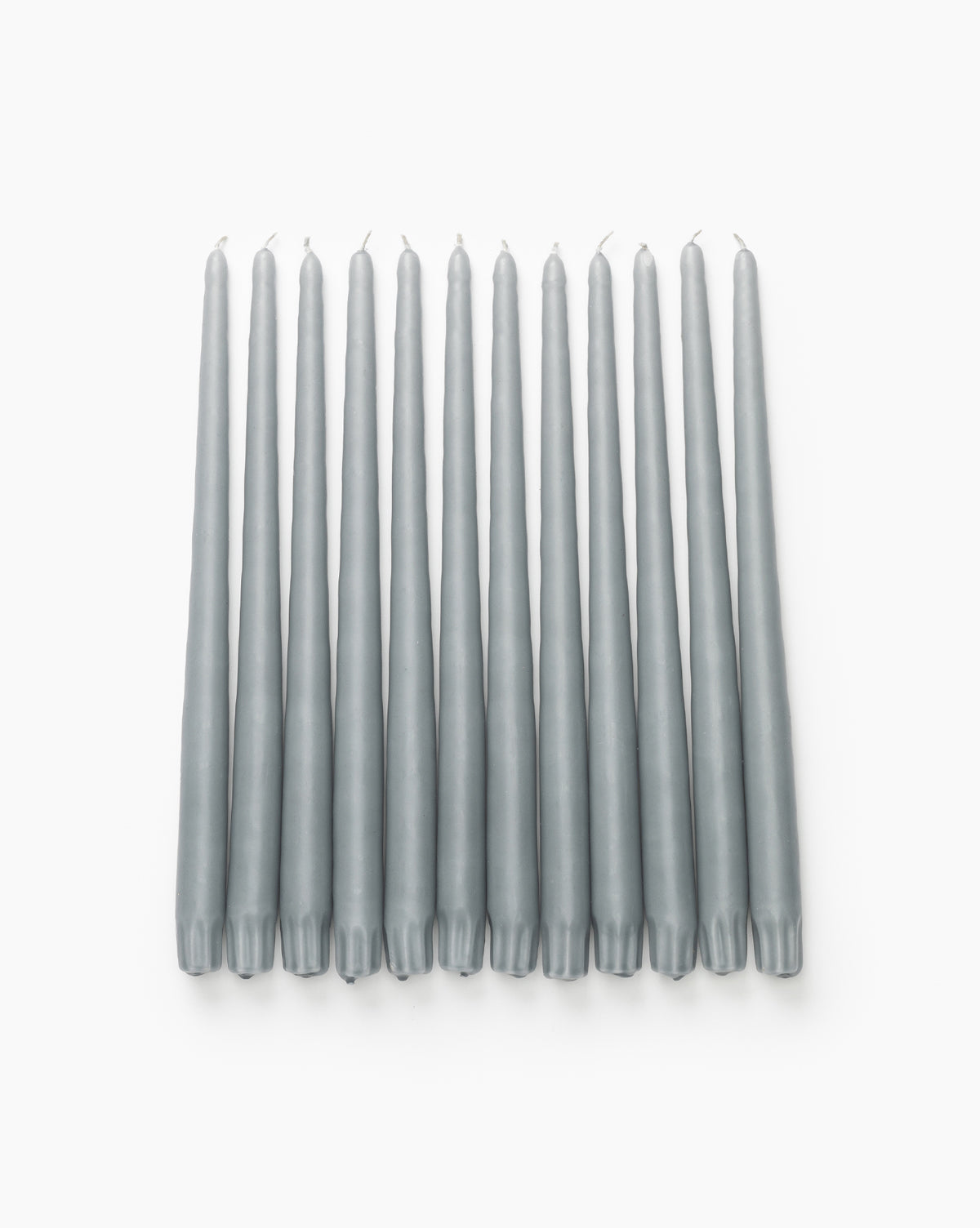 A set of 12 Light Gray Taper Candles is displayed side by side on a white background, their upward wicks ideal for bringing modern style and inviting candlelight to any space.