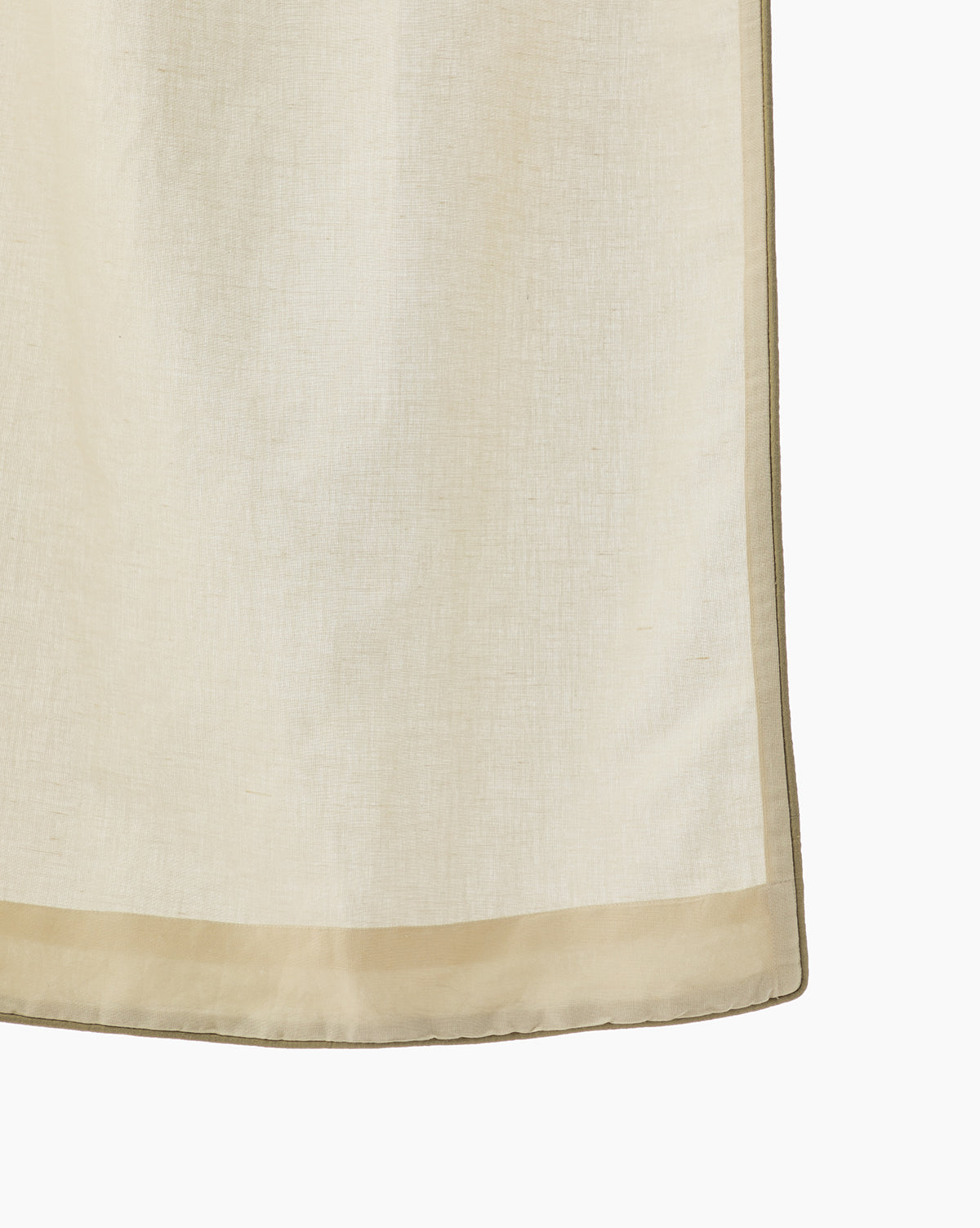 Close-up of the Lillian Linen Shower Curtain in light beige, semi-sheer linen-cotton, featuring a slightly darker hem on the left and bottom edges, hanging against a white background.