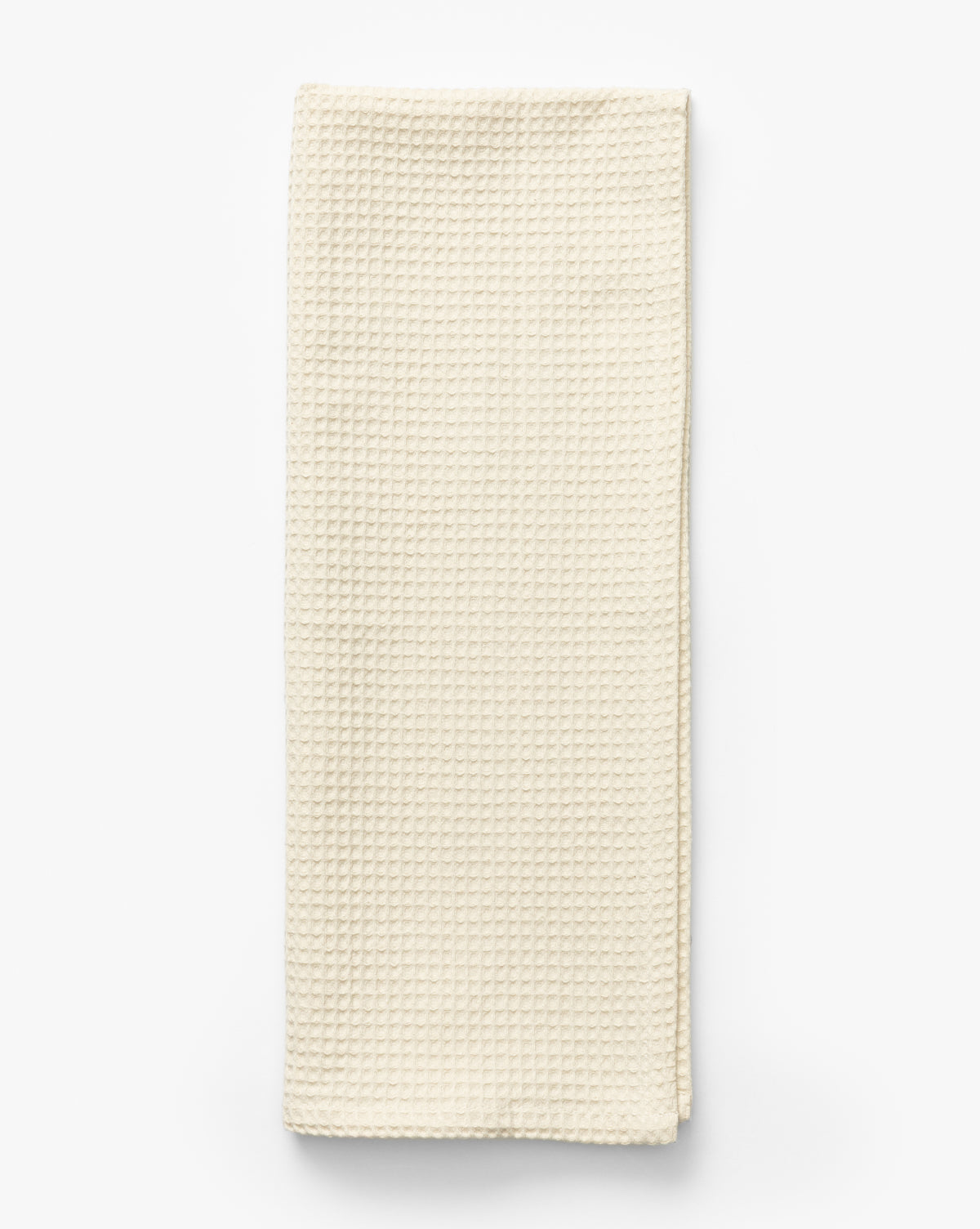 The Linen Blend Waffle Tea Towel, featuring a waffle weave texture in off-white, is folded neatly on a white background—an absorbent kitchen essential, by McGee & Co.