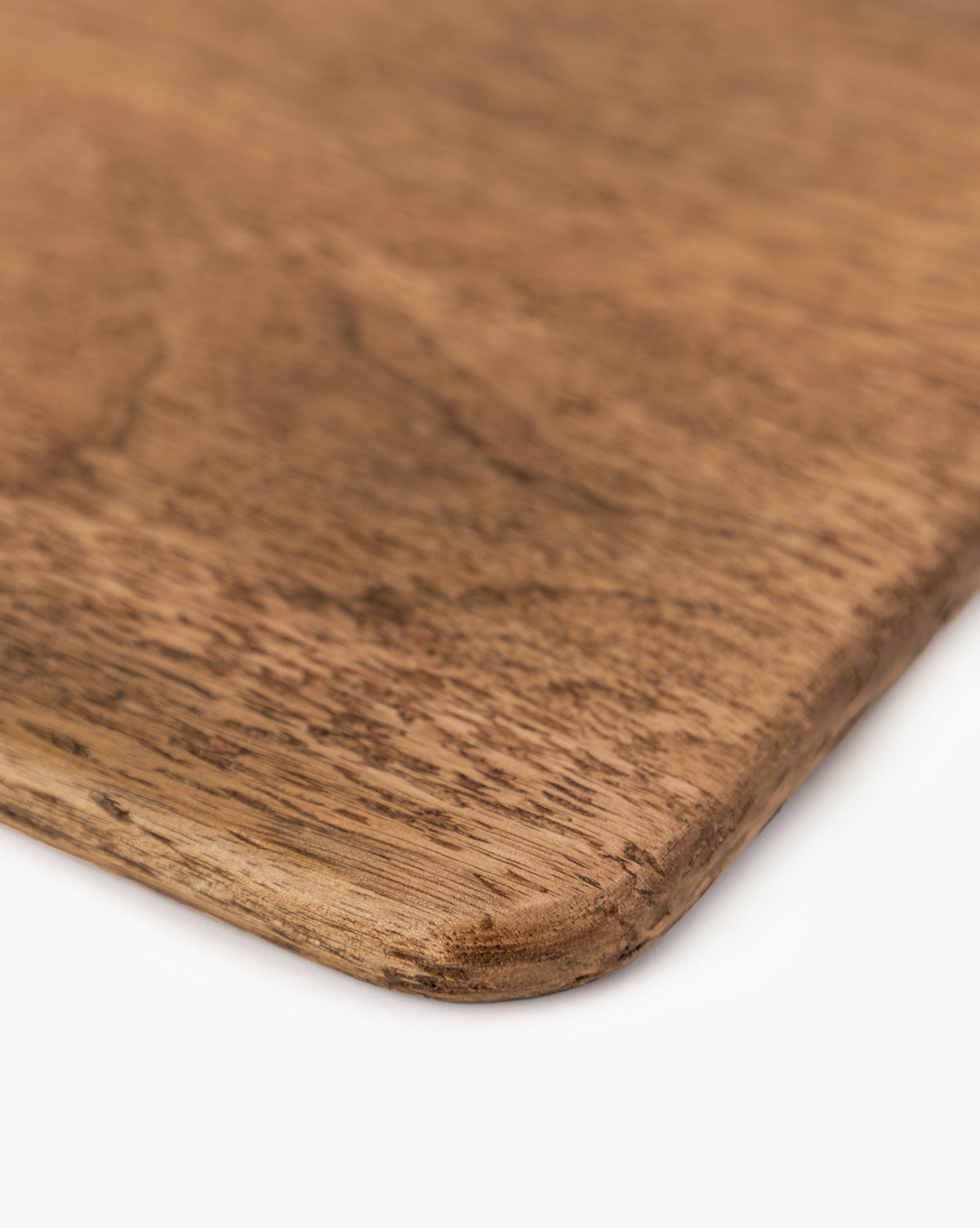 Close-up view of the Longfellow Breadboards corner, showcasing its smooth, rounded edge and natural mango wood grain against a white background—ideal for adding stylish flair to your kitchen decor, by McGee & Co.