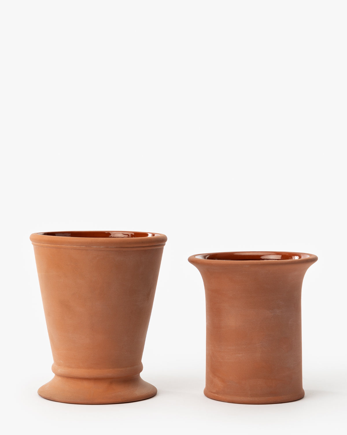 The Lorenzo Terracotta Pot set features a tall, flared-rim pot and a shorter, wide pot with an outward-curving rim—versatile planters ideal for both indoor and outdoor spaces, by McGee & Co.