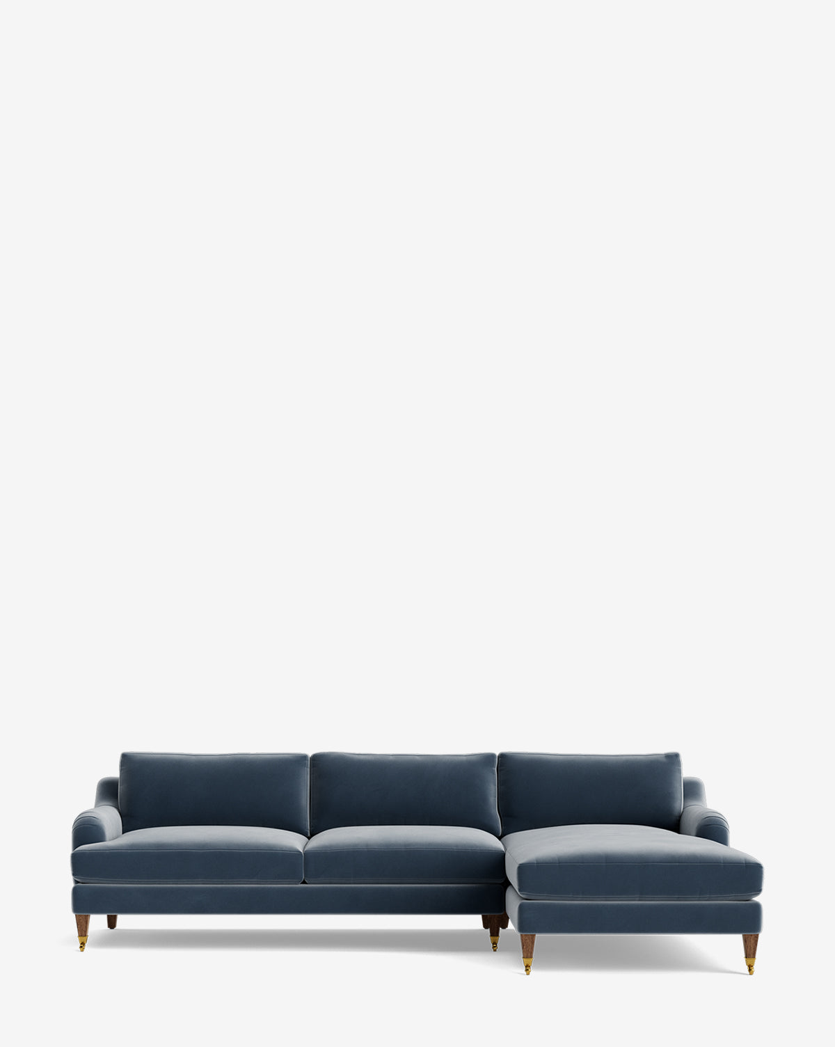 The Lucille English Roll Arm Right Chaise Sectional 107 is a modern blue velvet sofa with three down-wrapped cushions, a customizable chaise, rolled arms, and wooden legs with brass caps, shown against a plain white background by McGee & Co.
