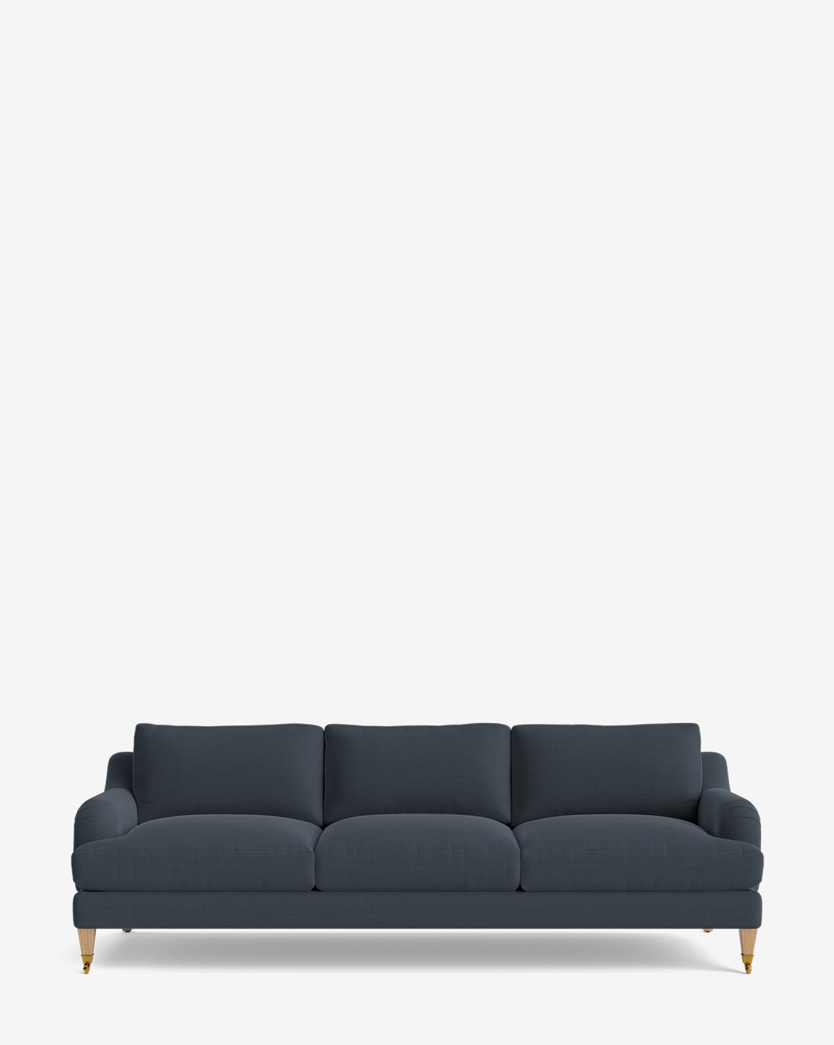 The Lucille English Roll Arm Sofa 90.5 is a dark blue, three-seater with down-wrapped cushions, gently rounded armrests, and wooden legs featuring brass-colored castors, shown against a plain white background by McGee & Co.