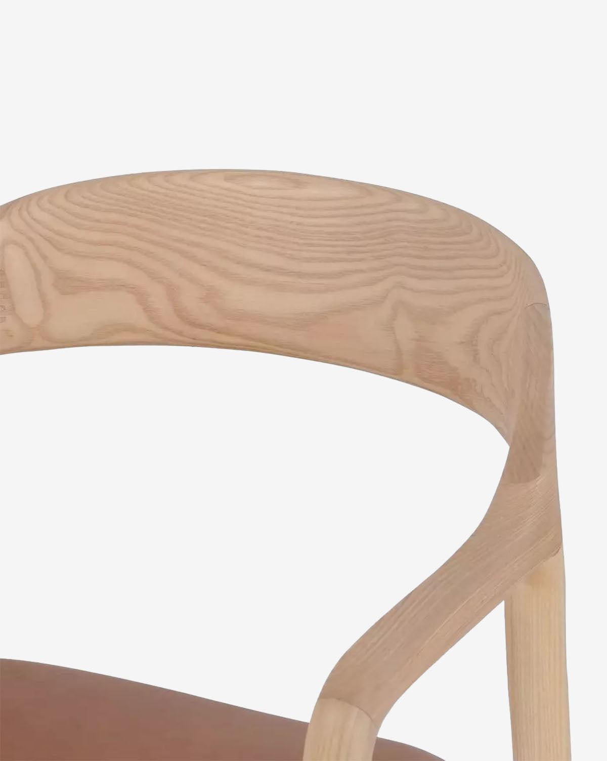 Close-up of the Lucinda Dining Armchairs curved backrest and armrest, highlighting its natural wood grain and sleek Scandinavian minimalist design set against a plain white background, by McGee & Co.