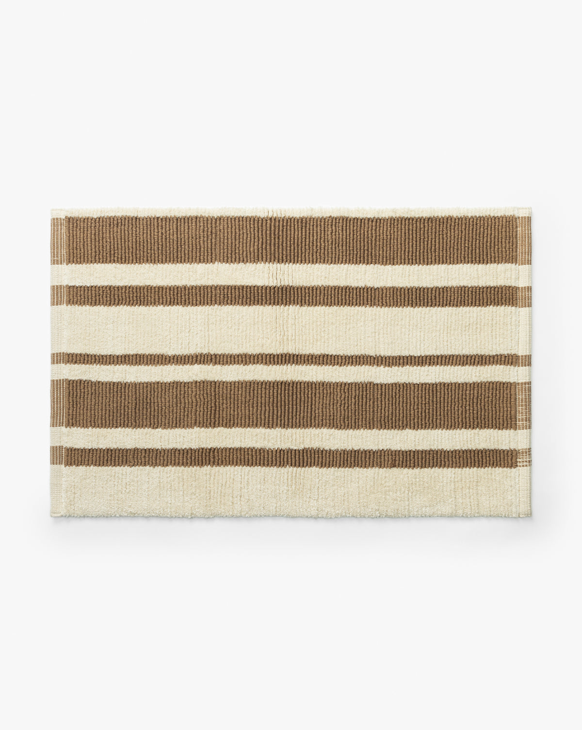 The Lyall Bath Mat is a rectangular, hand-woven cotton mat with beige and light brown horizontal stripes on a white background, perfect for elevating your bathroom decor, by McGee & Co. Shown here against a white surface.