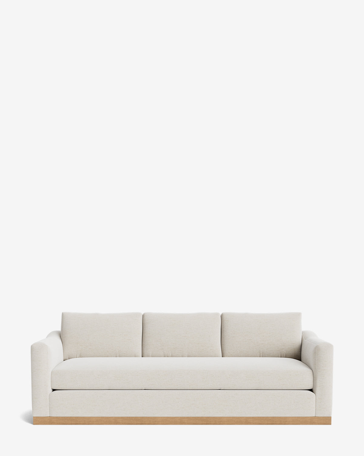 The Vernon Sofa 92 by Community is a modern three-seater with light beige velvet, square arms, three back cushions, and a wooden base—an ideal customizable sofa for any contemporary space. McGee & Co.