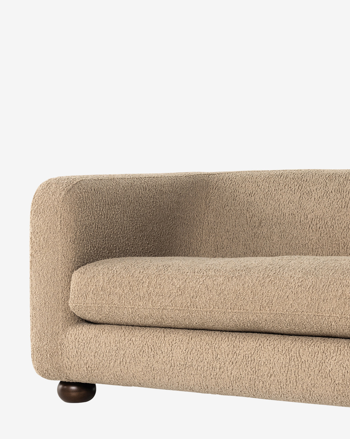 A close-up of the Four Hands Quill Sofa 84 in modern beige faux shearling, featuring textured upholstery, rounded armrest, and a visible dark wooden leg, set against a plain white background. McGee & Co.