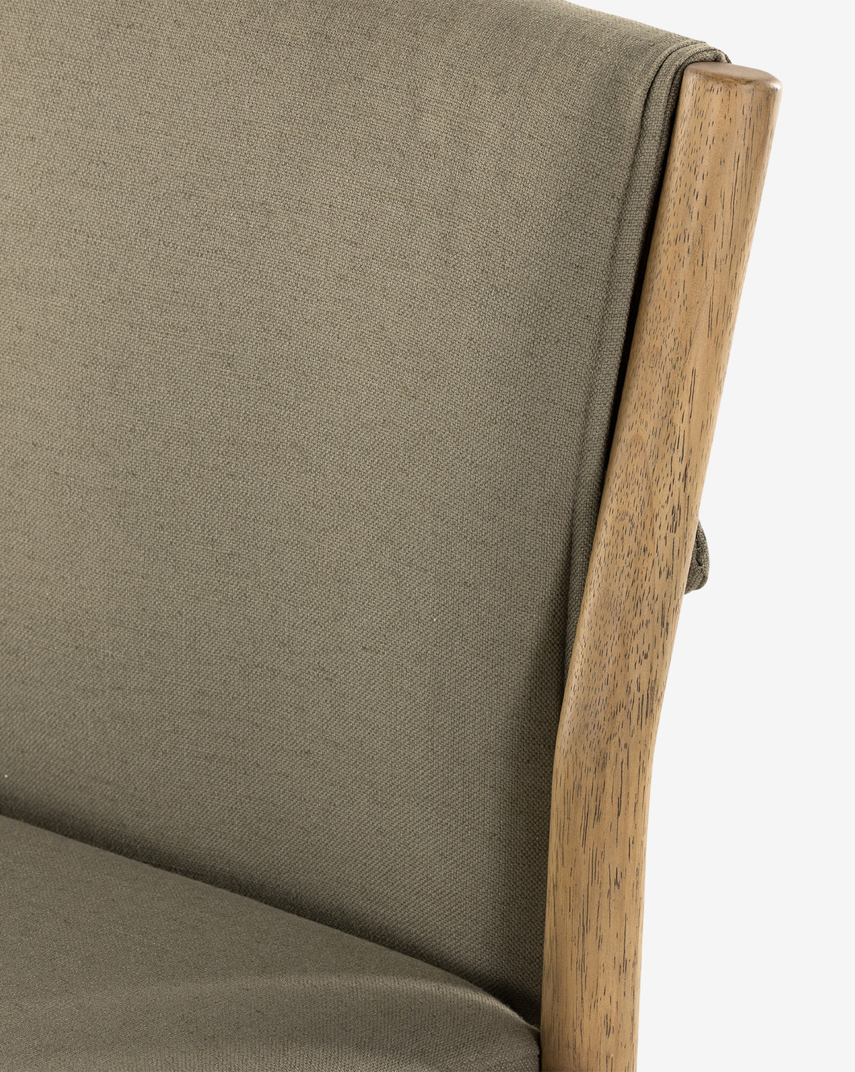 Close-up of the Bardot Dining Chair, featuring olive green high-performance fabric upholstery and a smooth, natural parawood frame, highlighting the backrest and part of the seat by McGee & Co.