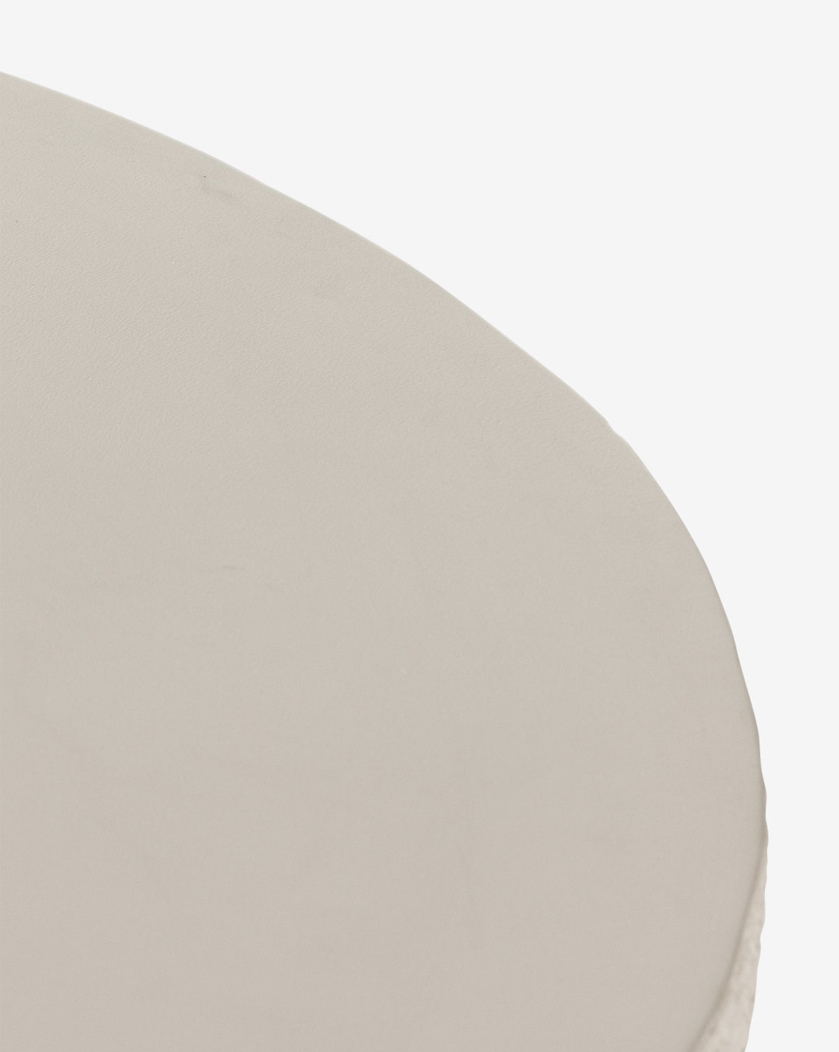 A close-up of the Atalanta Outdoor Dining Table’s smooth, round, light beige surface against a white background, by McGee & Co.