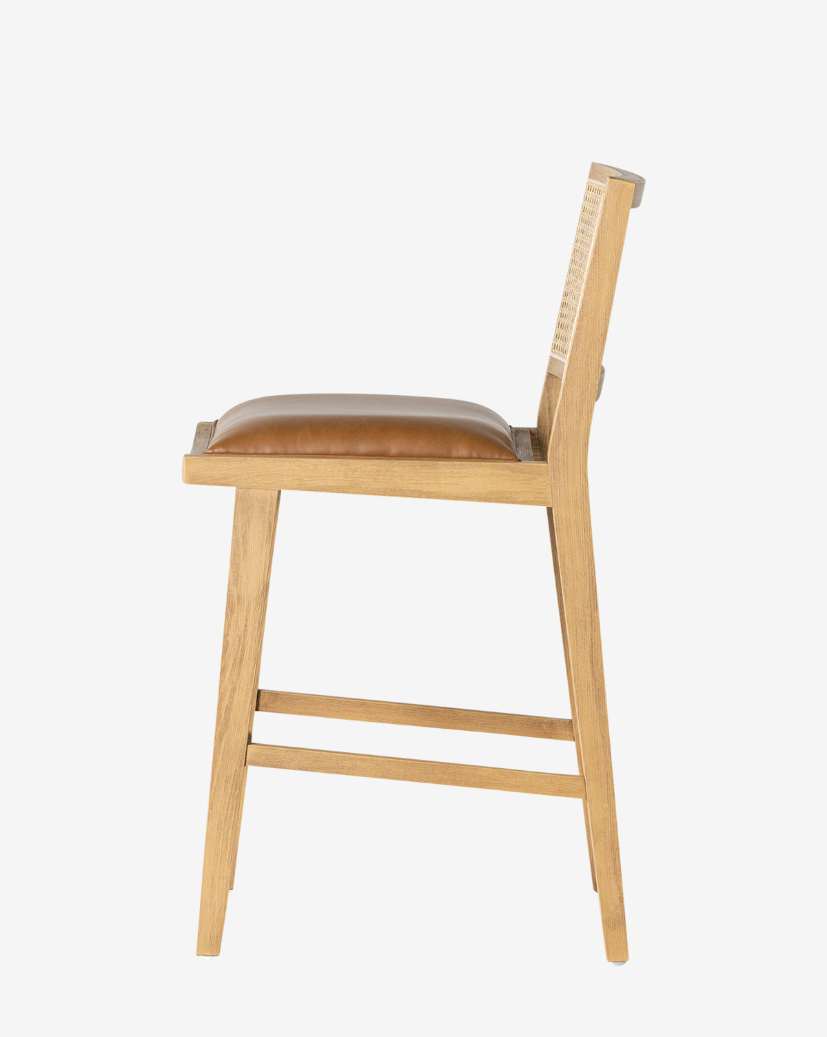 Side view of the Emeline Stool, showcasing its solid beech frame, tan faux leather cushion, minimalist backrest, and angled legs with support bars against a plain white background by McGee & Co.
