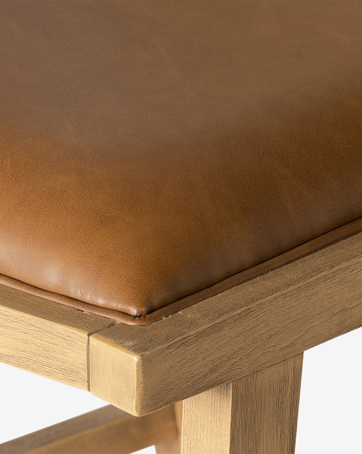 Close-up of the Emeline Stool, showcasing its solid beech frame and light brown faux leather cushion. The image emphasizes the cushion’s texture and the wood’s smooth finish, by McGee & Co.