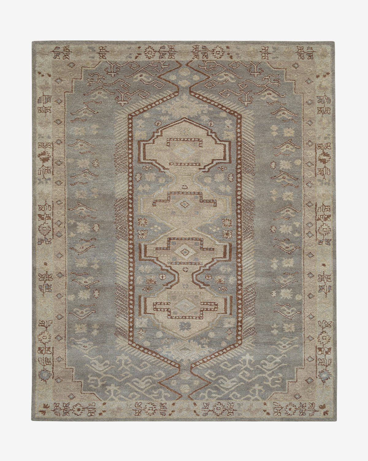 The Lazio Handwoven Wool Rug is a rectangular wool rug showcasing a central geometric pattern in muted gray, beige, and brown, bordered with traditional motifs and symmetrical details, by McGee & Co.