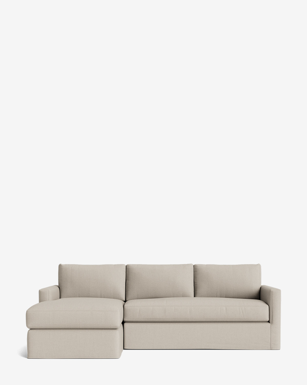 The Macy Slipcover Chaise Sectional 101 features light beige fabric, three seat cushions, three back cushions, and a left-side chaise lounge, shown against a plain white background by McGee & Co.