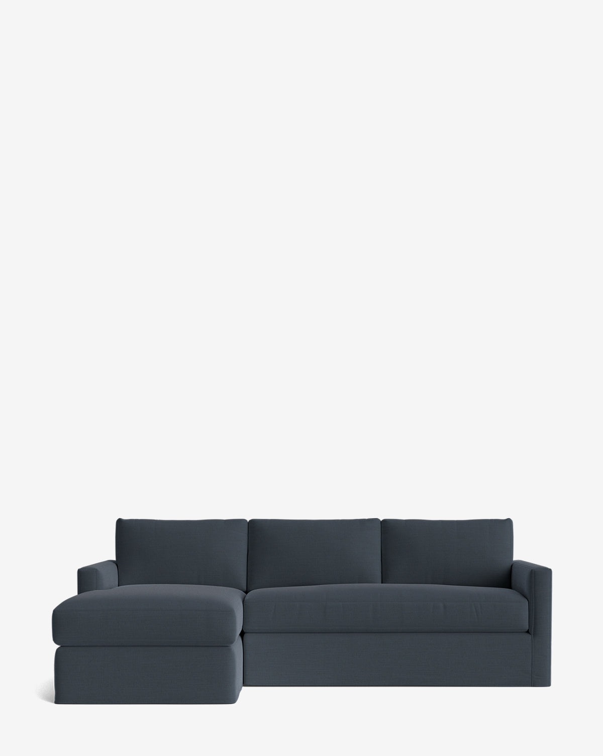 The Community Macy Slipcover Chaise Sectional 101 in dark blue features a deep design with three back cushions and a left-side chaise lounge, displayed against a plain white background. McGee & Co.