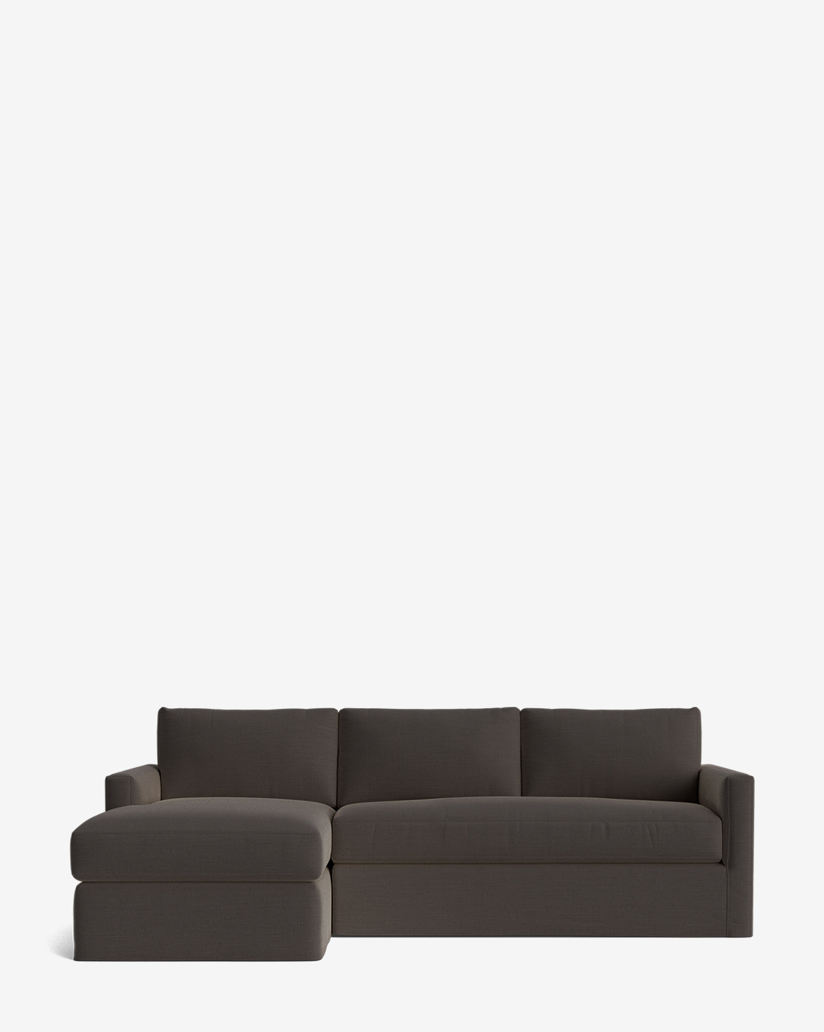 The Community Macy Slipcover Chaise Sectional 101 in modern dark gray features a left-side chaise lounge, three back cushions, and low armrests, shown on a plain white background for a sleek appearance. McGee & Co.
