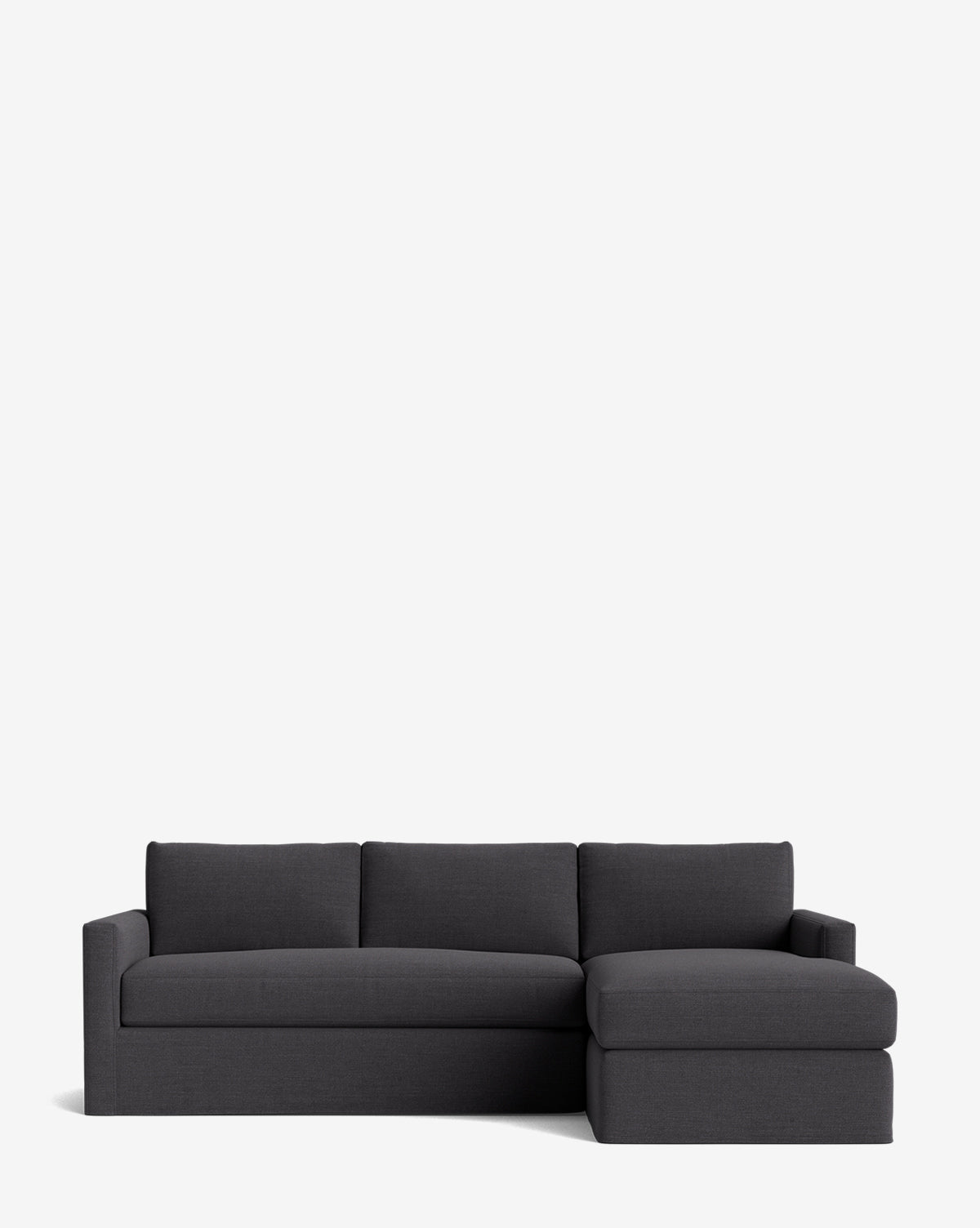 The Macy Slipcover Chaise Sectional 101 is a modern, dark gray customizable sofa with three seat cushions and a right-side chaise lounge, shown against a plain white background by McGee & Co.