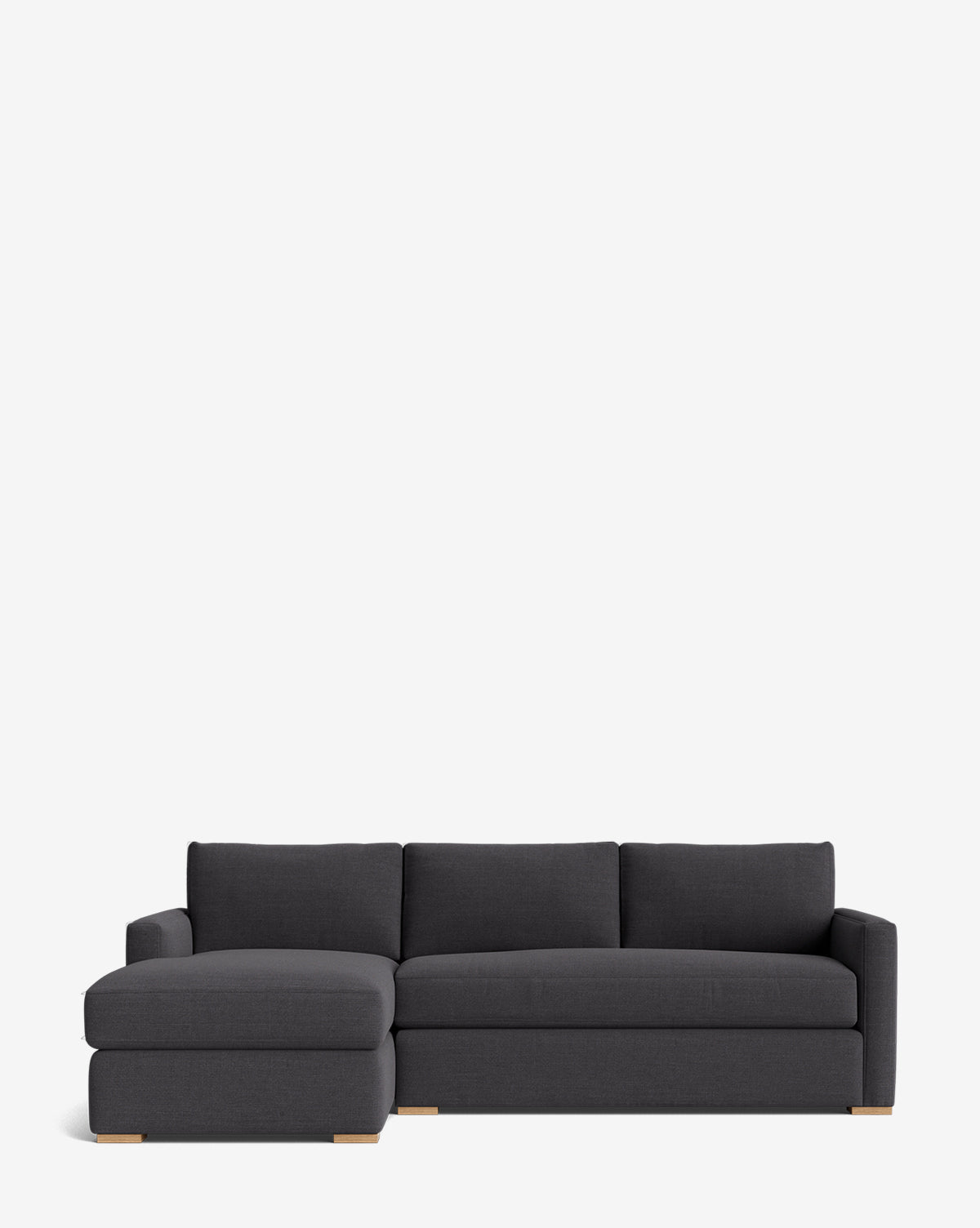 The Community Macy Upholstered Chaise Sectional 101 features a modern dark gray design with a left-facing lounge, three back cushions, and low wooden block feet, shown against a plain white background, McGee & Co.
