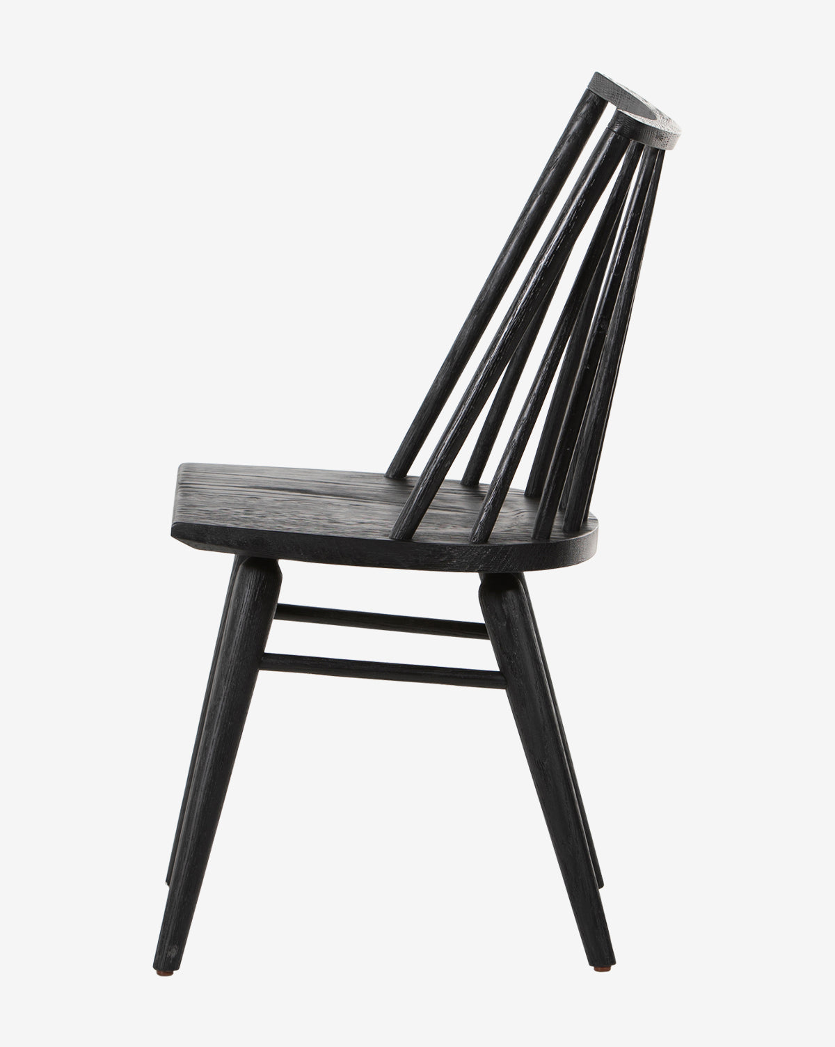 The Madison Dining Chair is shown in profile against a white background. It features a black finish, flat seat, angled legs, and a curved backrest with vertical spindles by McGee & Co.