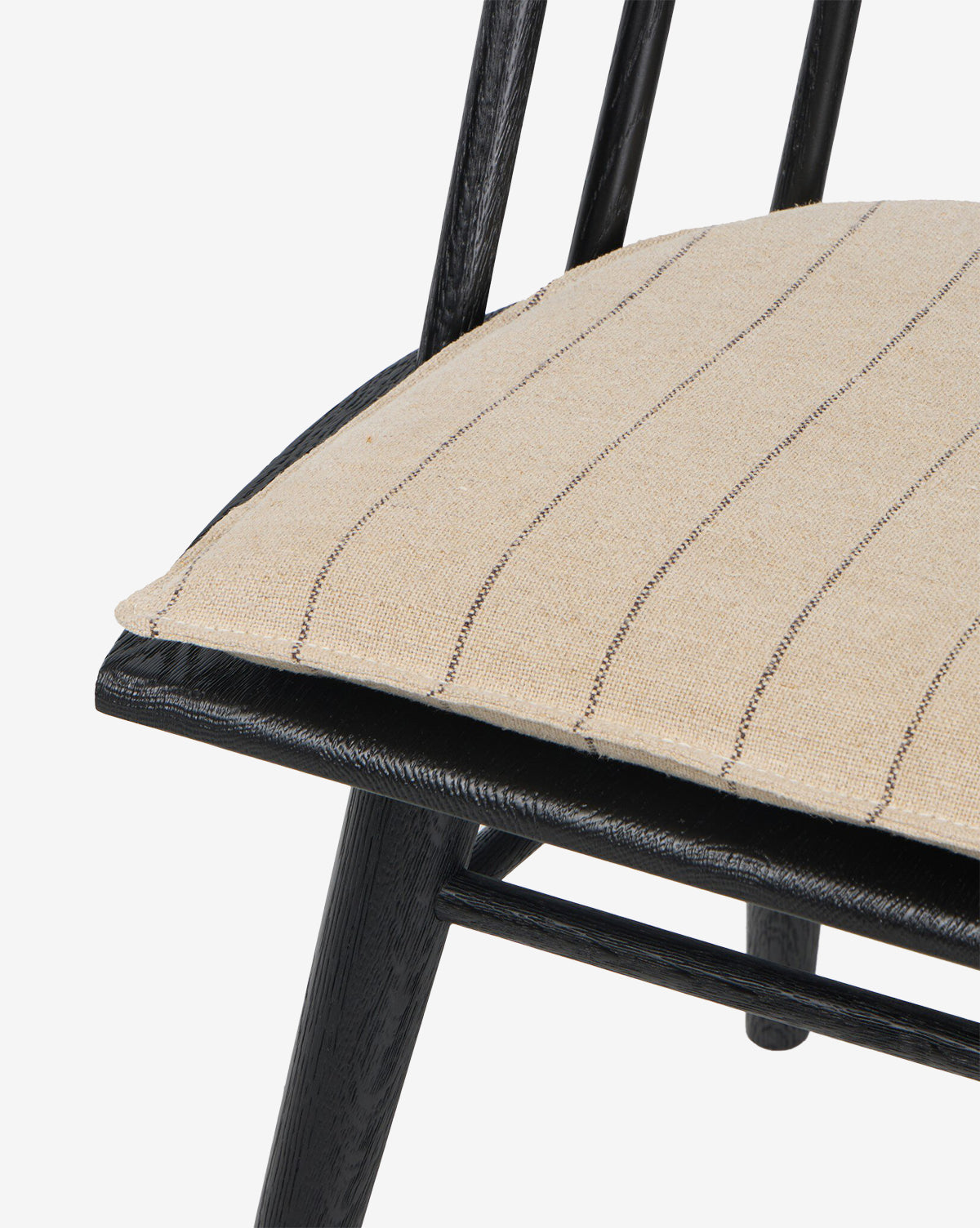 Close-up of the Madison Dining Chair, featuring a contemporary black wooden frame and a beige cushion with thin, evenly spaced black stripes by McGee & Co.