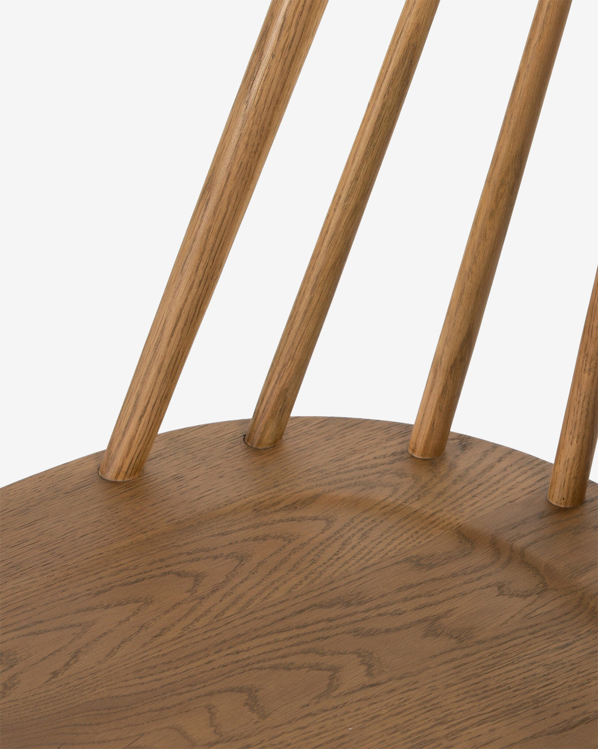 Close-up of a Madison Dining Chair seat featuring four vertical, rounded wooden backrest spindles, showcasing the wood grain and smooth, natural finish by McGee & Co.