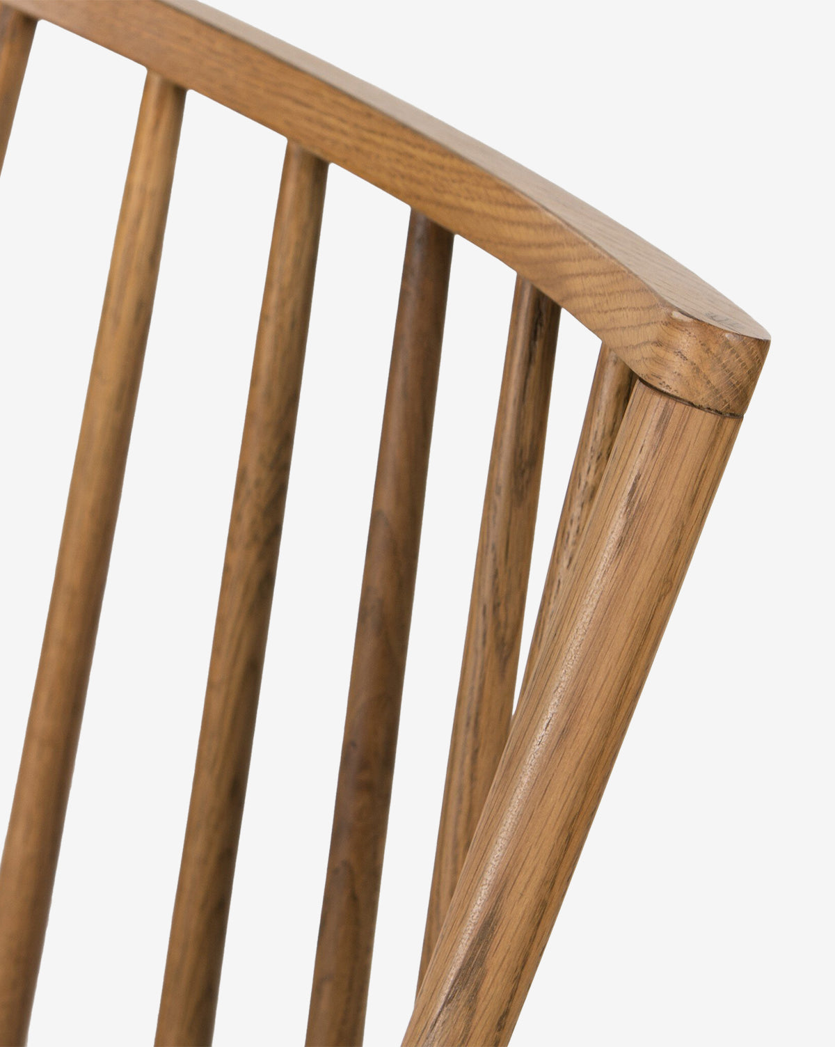 Close-up of the Madison Dining Chair’s oak backrest, showing its vertical slats and curved top rail, set against a plain white background, by McGee & Co.