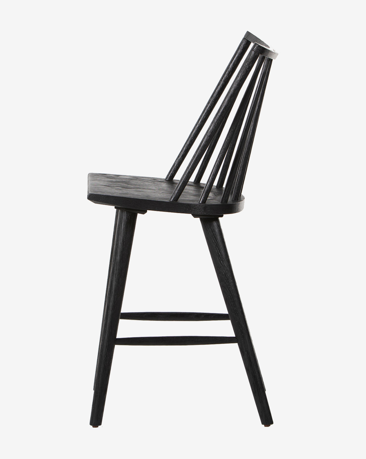 The Madison Stool is a black wooden Windsor-style stool with a round seat, slanted backrest of vertical slats, and angled legs, shown in profile against a white background.