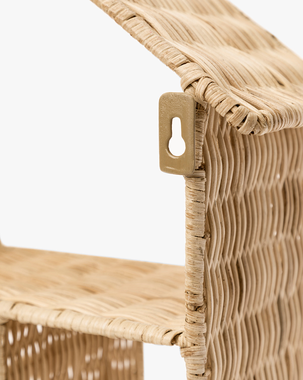 Close-up of the Maison Shelf, a woven light rattan wall shelf with a slanted roof, metal keyhole hanger, and natural finish. Its house-shaped design adds an organic touch to any space by McGee & Co.