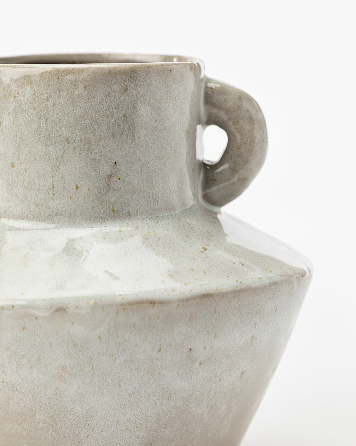 Close-up of the Malaga Vase, featuring smooth stoneware with a light gray-white reactive glaze and a single handle near the neck, displayed against a plain white background.