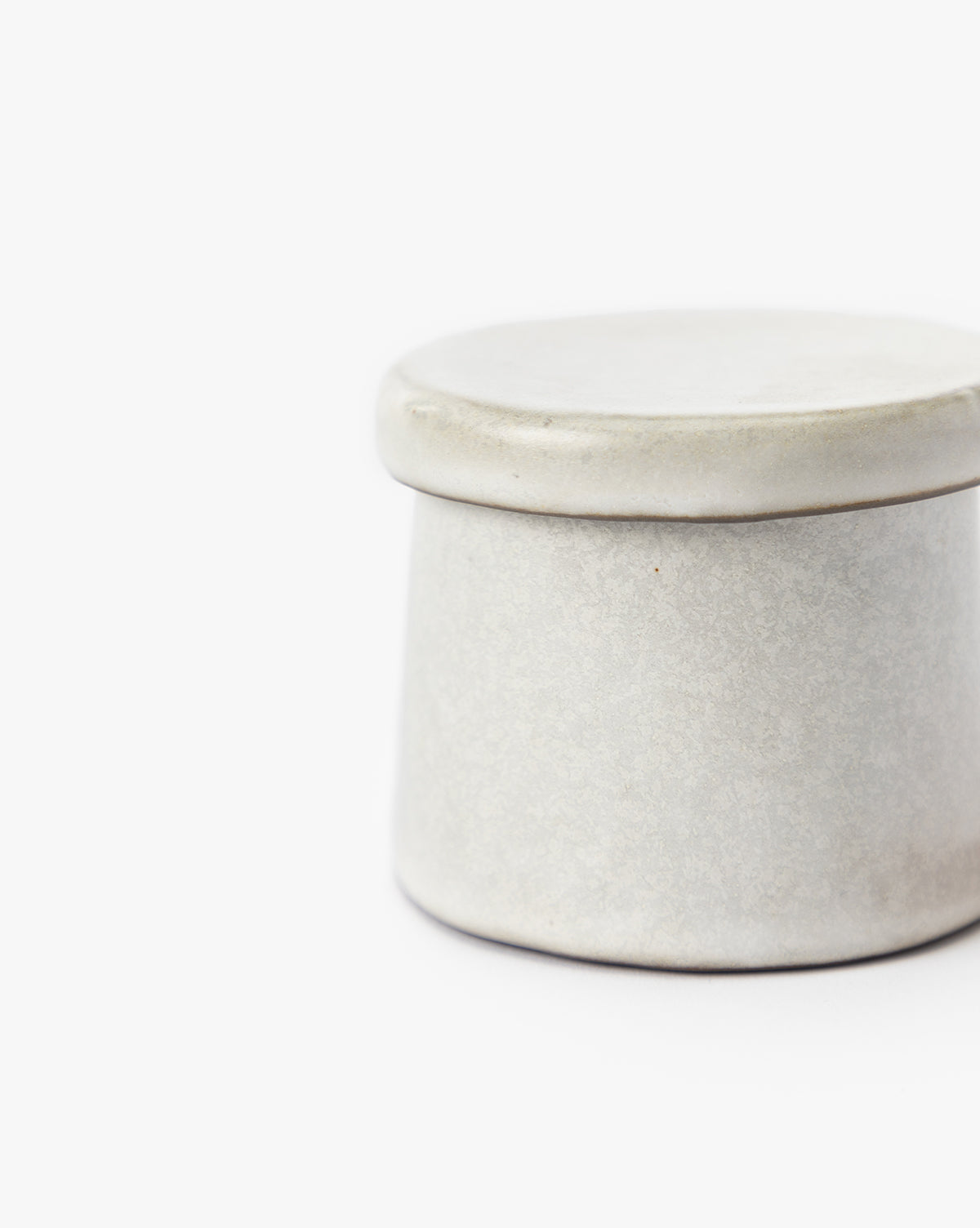 A simple, round Malco Salt Cellar in light gray with a matching lid is shown against a white background. Only part of the ceramic container is visible in the image.