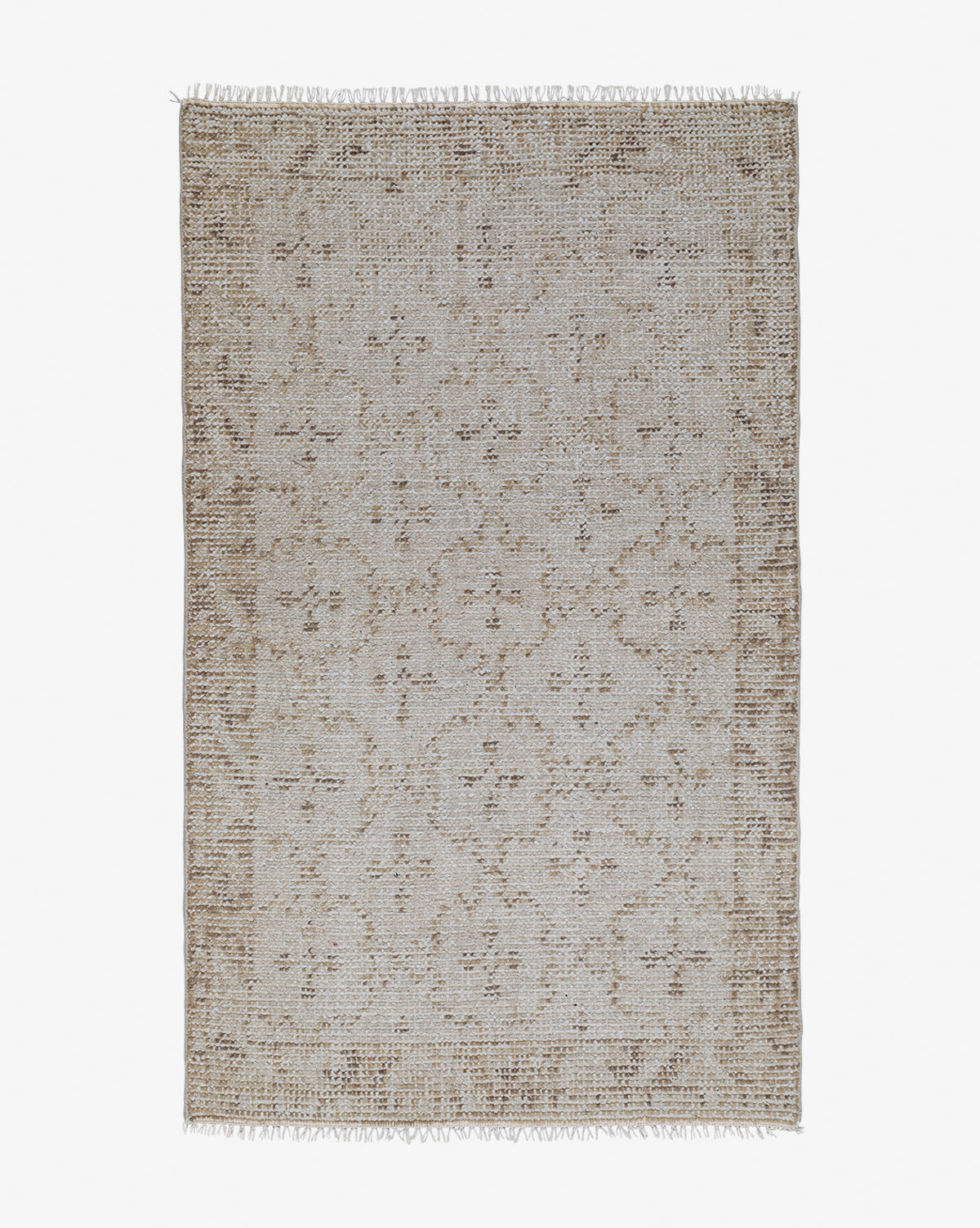 The Mali Hand-Knotted Rug is a rectangular neutral piece with a beige and brown geometric pattern and fringed short edges, shown on a white background, by McGee & Co.