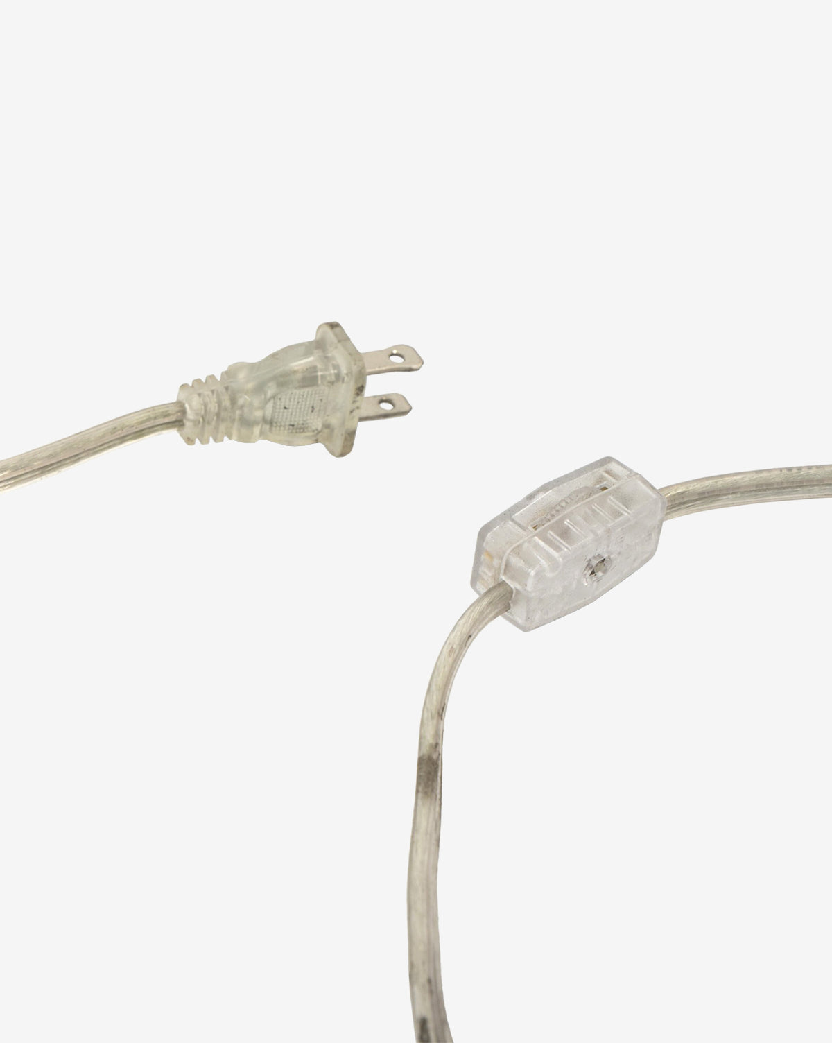 The Malinska Table Lamp features a transparent electrical plug and cord with an inline switch, all made of clear plastic—ideal for pairing with an Italian marble base and a linen dome shade, shown against a plain white background, by McGee & Co.