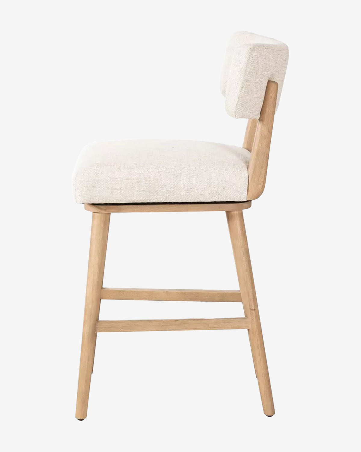 The Four Hands Mance Swivel Stool features light wood legs and a beige upholstered seat and backrest, shown in a side view against a plain white background, McGee & Co.