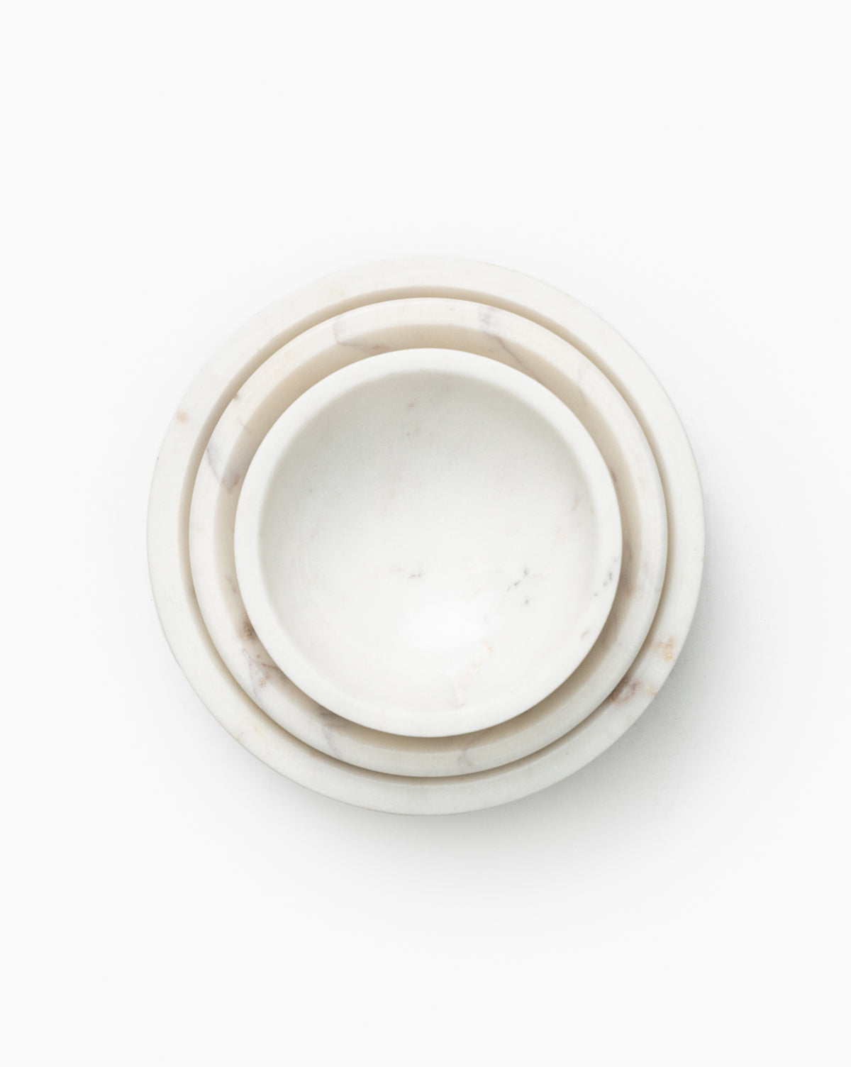 The Marble Nesting Bowls (Set of 3) feature round, white marble bowls in varying sizes, neatly nested together on a plain white background for a stylish, modern look.
