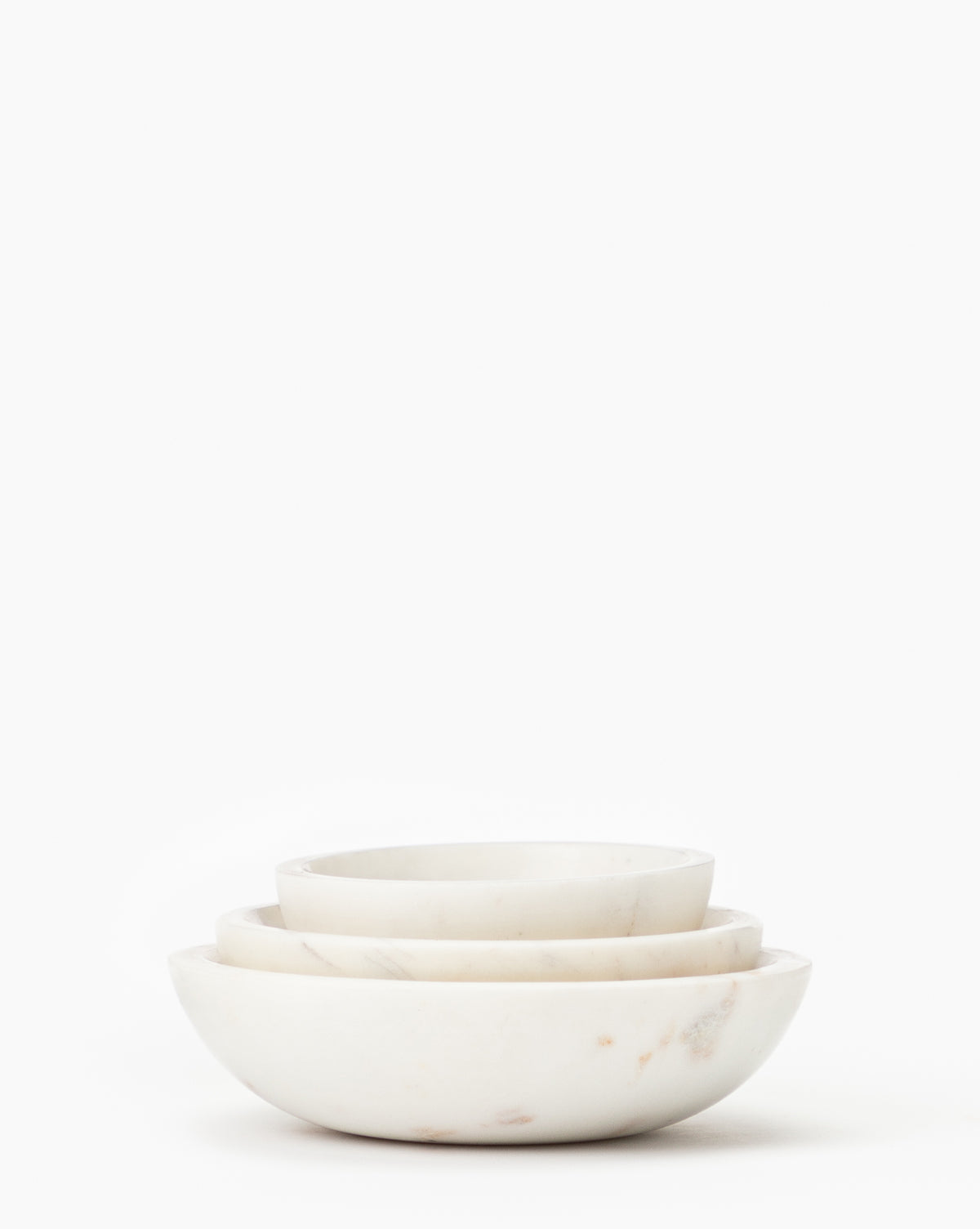 The Marble Nesting Bowls (Set of 3) features elegant white marble bowls in different sizes, neatly stacked to create a stylish designer look against a plain white background.