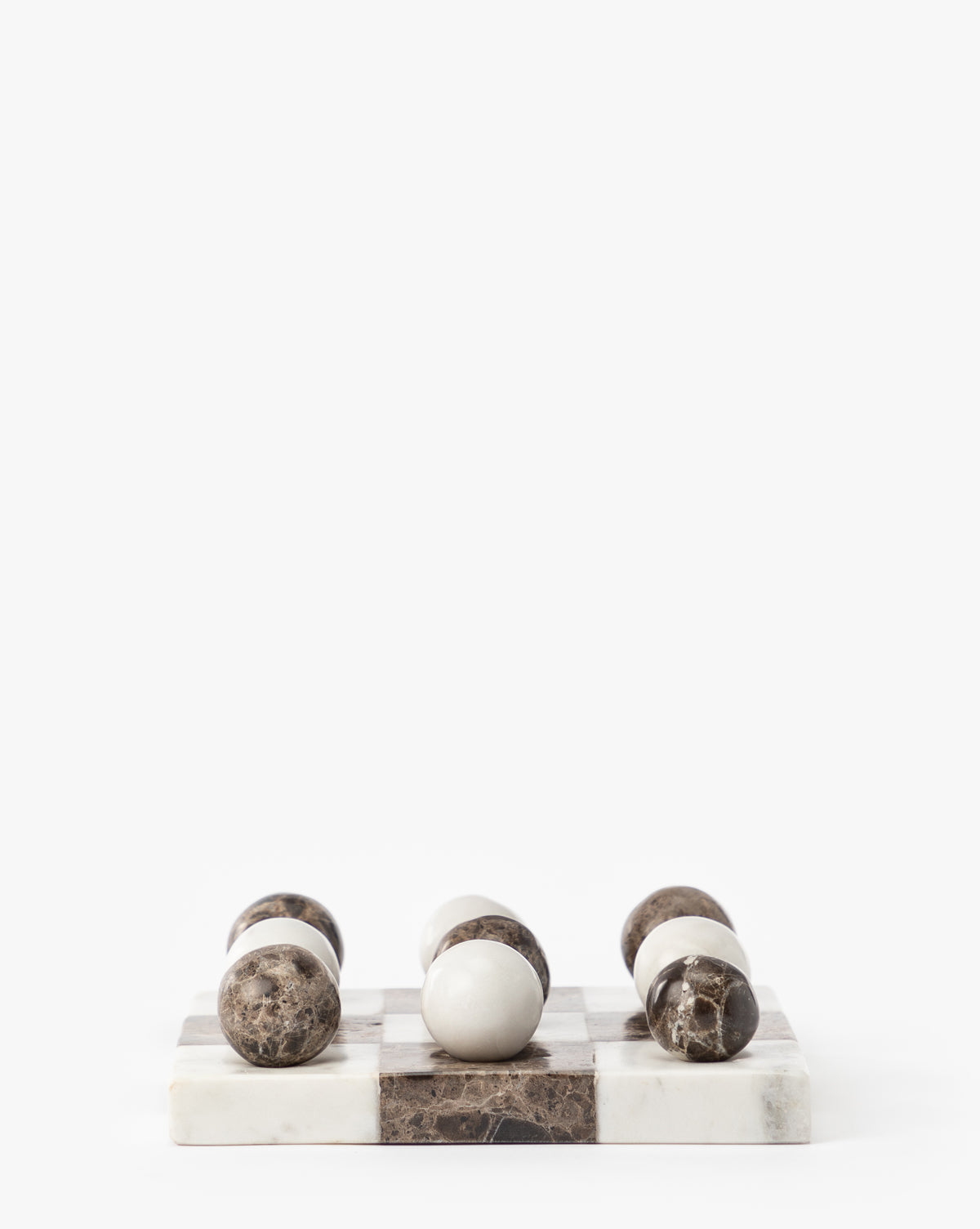 A minimalist Marble Tic-Tac-Toe Board with polished, round game pieces on a marble board featuring alternating white and brown squares—ideal as marble coffee table decor against a crisp white background.