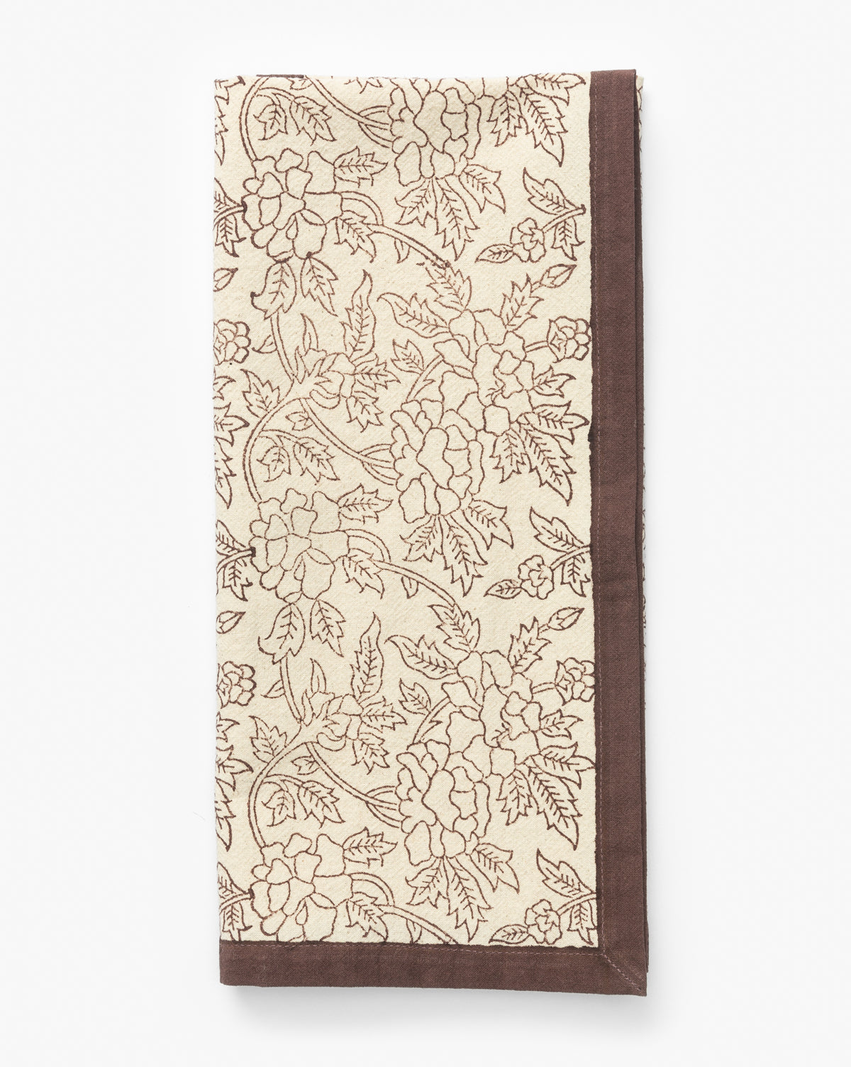 A beige cloth napkin with a brown floral and leaf pattern and a solid brown border is neatly folded on a white background—ideal for kitchen decor or pairing with the Marceline Cotton Tea Towel, by McGee & Co.